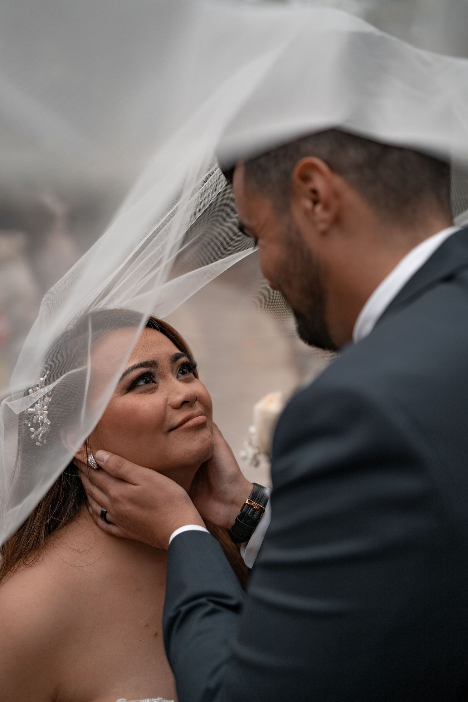 Intimate wedding portrait showing tender moment between bride in veil and groom.
