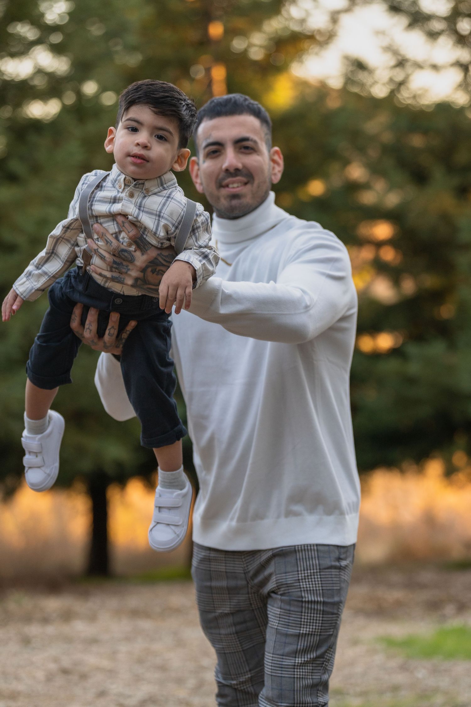 Joyful family moment captured in natural outdoor setting with golden sunlight.