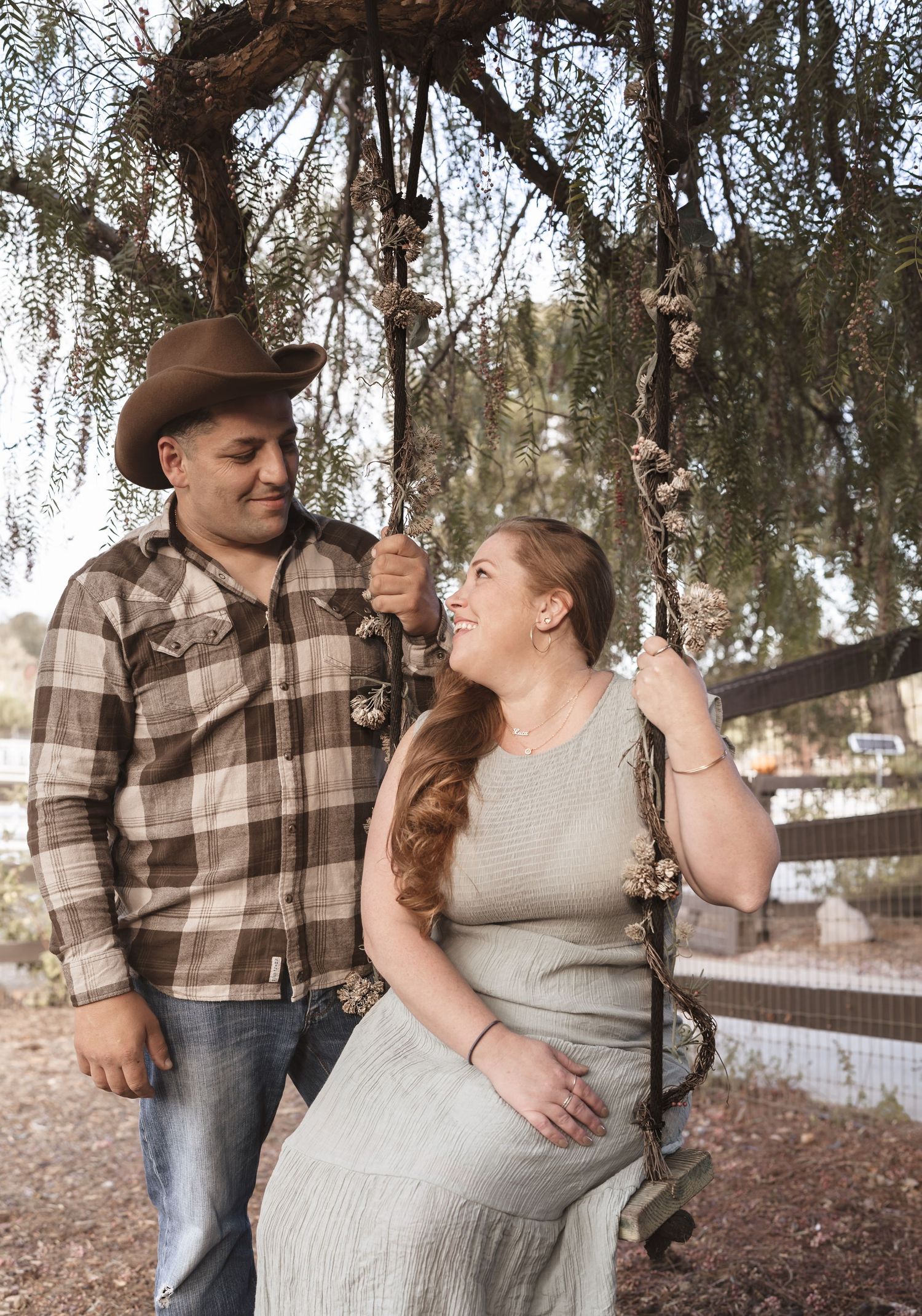 Playful outdoor portrait session under drooping tree branches.