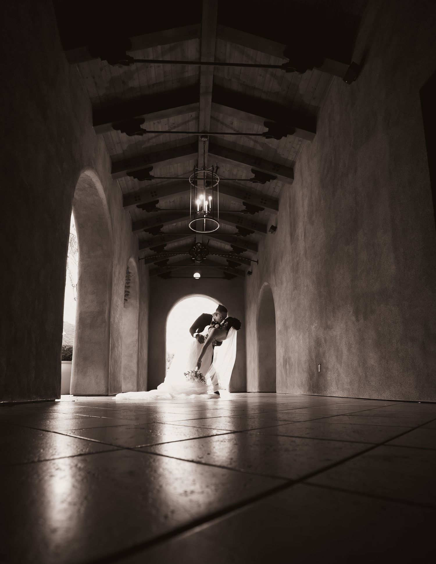 A dramatic series of black and white photographs showing a dark corridor with bright light streaming through an arched doorway.