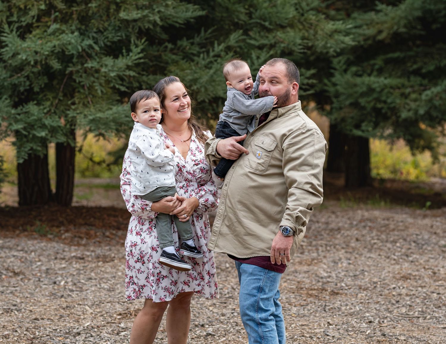 Family members share candid moments and laughter during outdoor photo session.