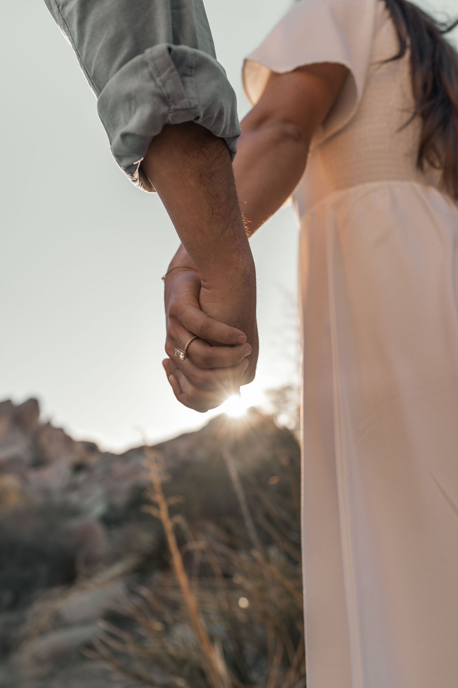 Artistic silhouette of a couple standing together against a desert landscape at sunset.