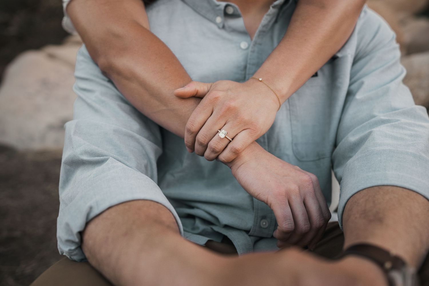 Close-up details of hands and casual clothing during an outdoor desert photoshoot.
