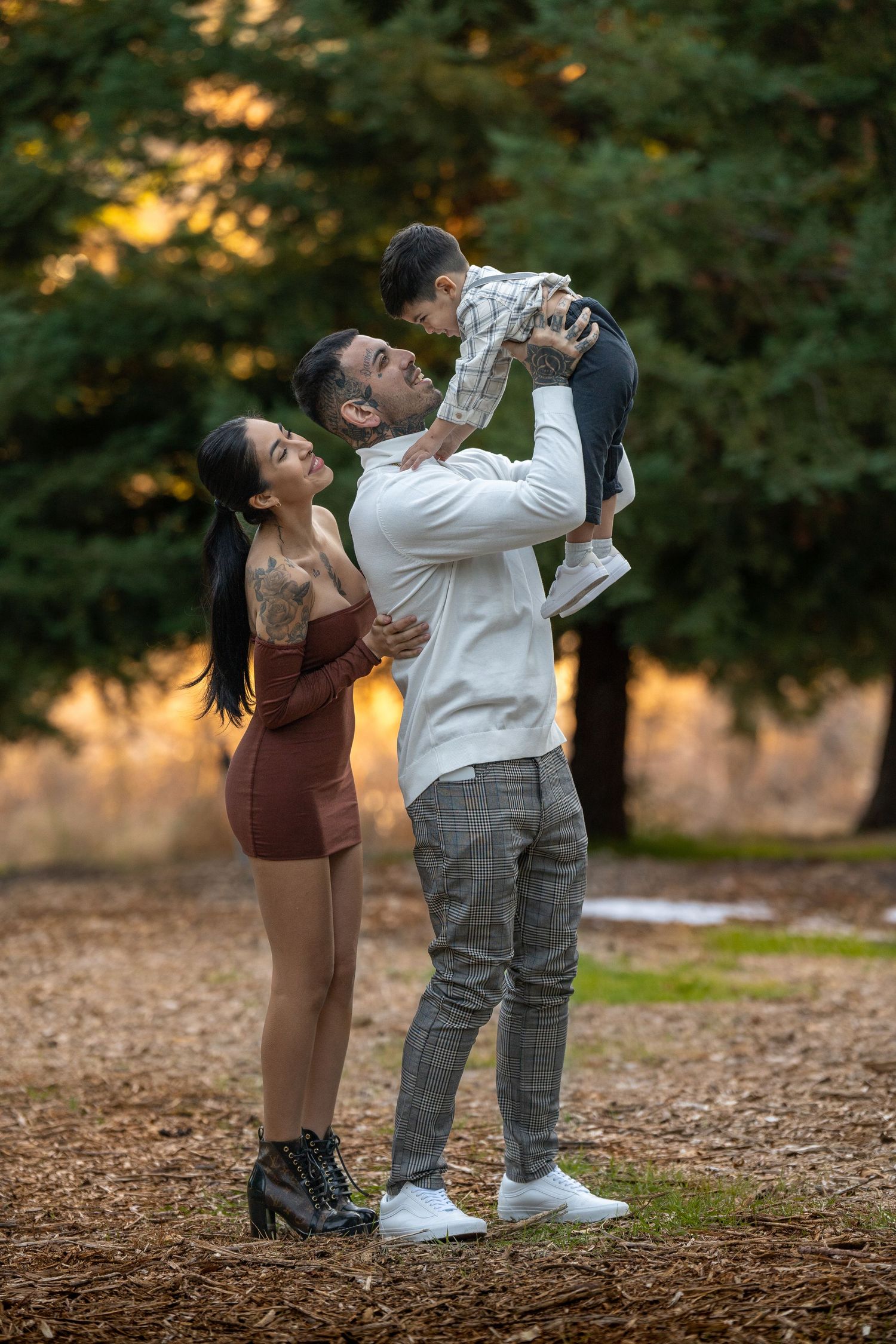 Family shares playful moments together on autumn ground covered in leaves.
