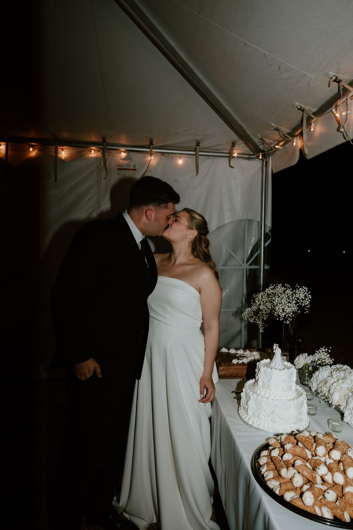 Wedding reception under tent with cake and cupcake display.