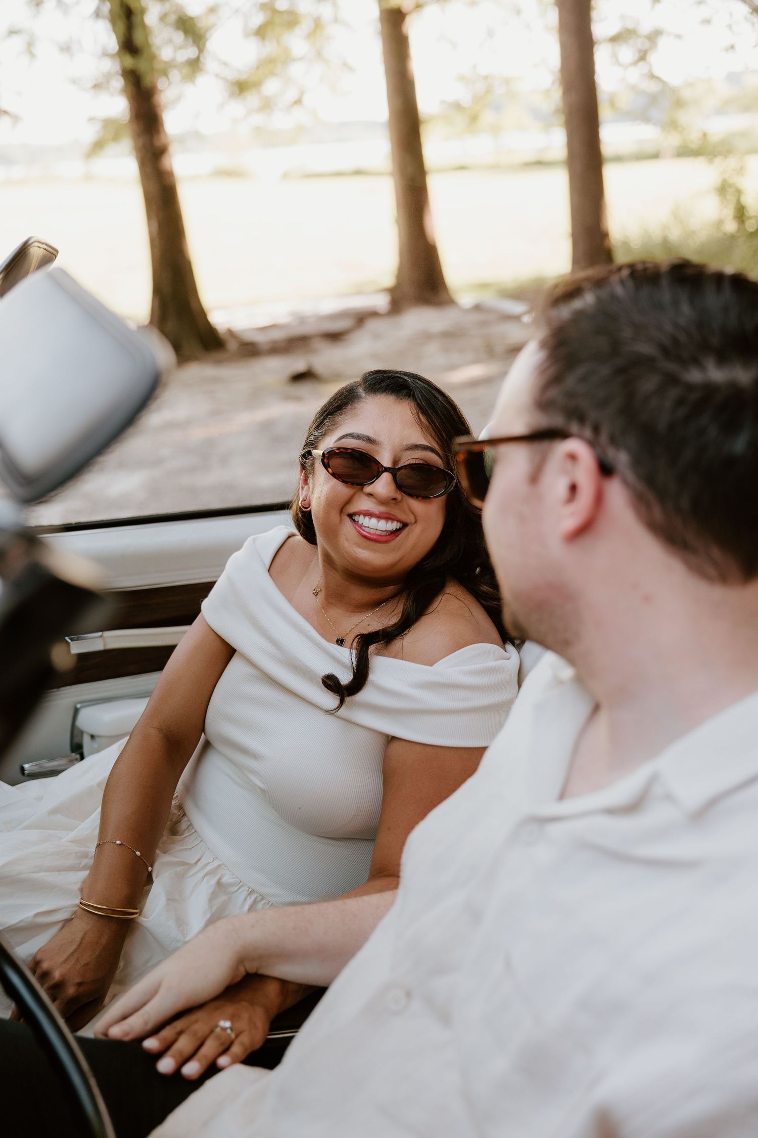Candid car moment between couple showing genuine laughter and joy.