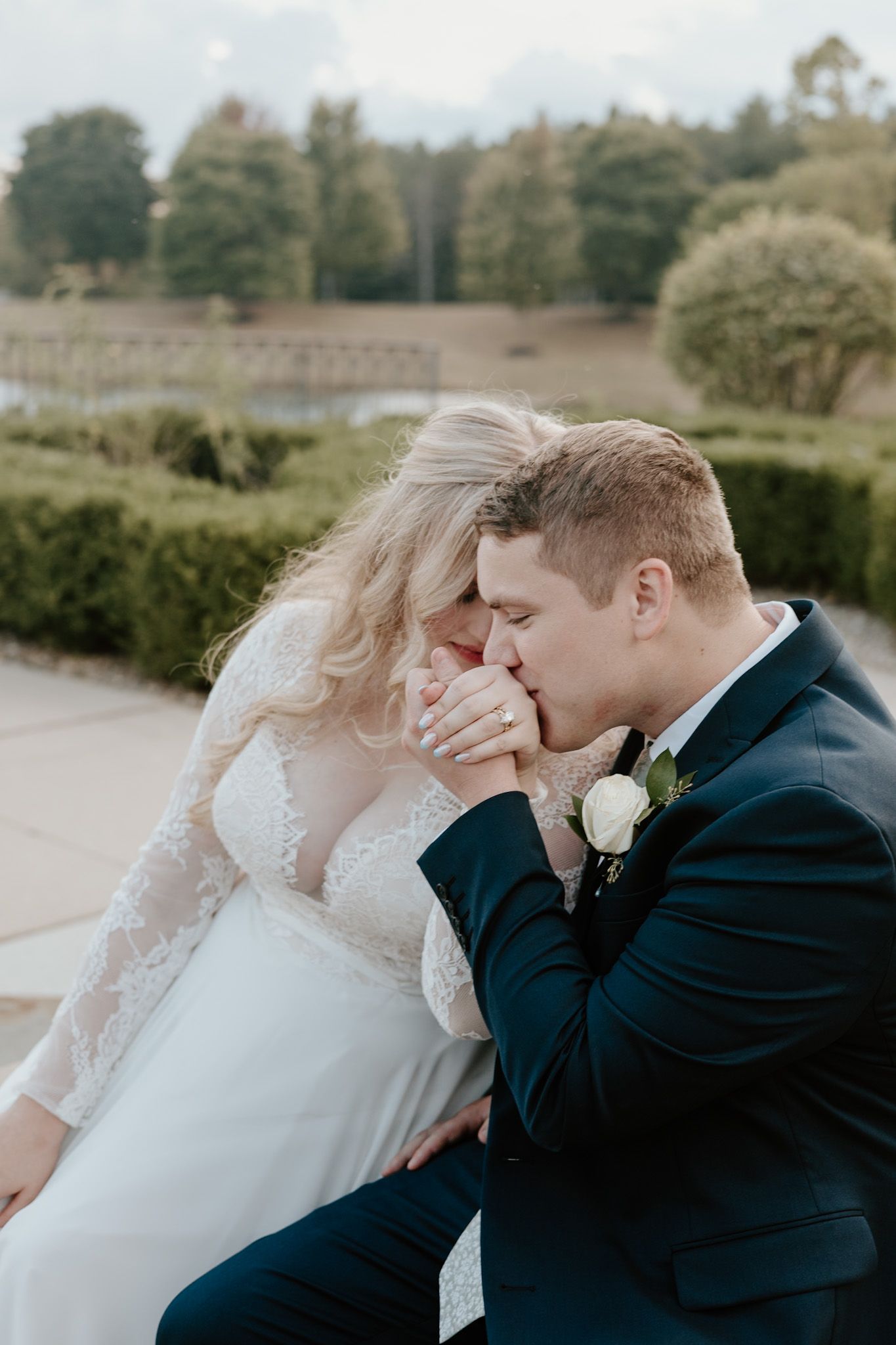 Romantic tender moment captured between newlyweds in an outdoor setting with natural lighting.