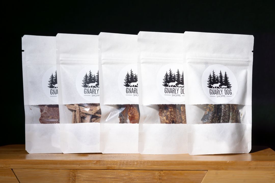 Row of white coffee bags with custom branding lined up on wooden surface showing retail coffee packaging display.