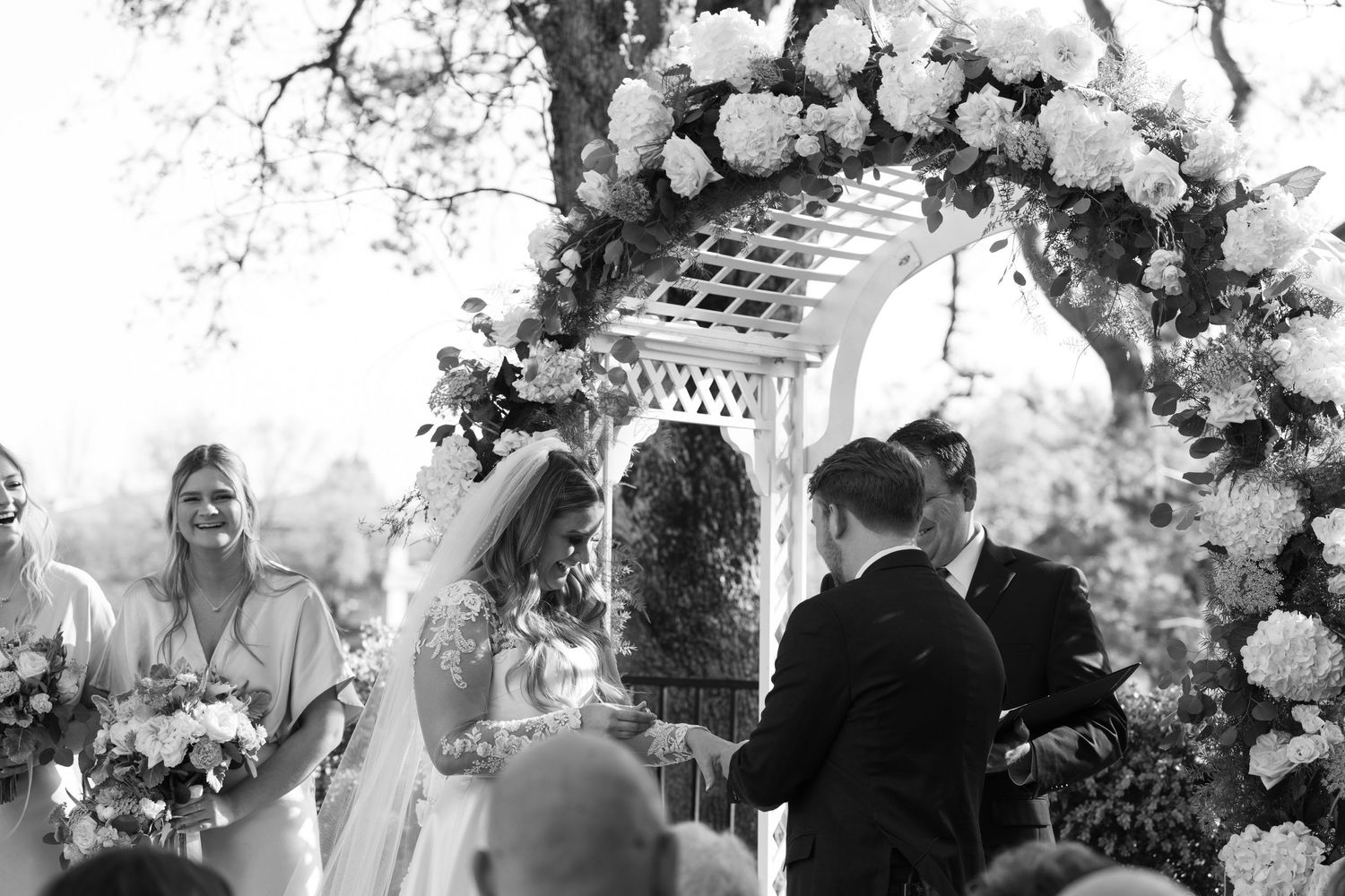 Lodi wedding photographer captures bride and groom exchanging vows under floral arch—romantic outdoor ceremony, timeless wedding photography