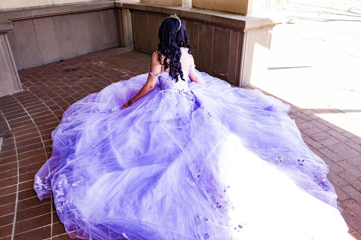 An elegant lavender ball gown with a dramatic train photographed from behind on tiled stairs in Lodi by Katie Malinda Photography.