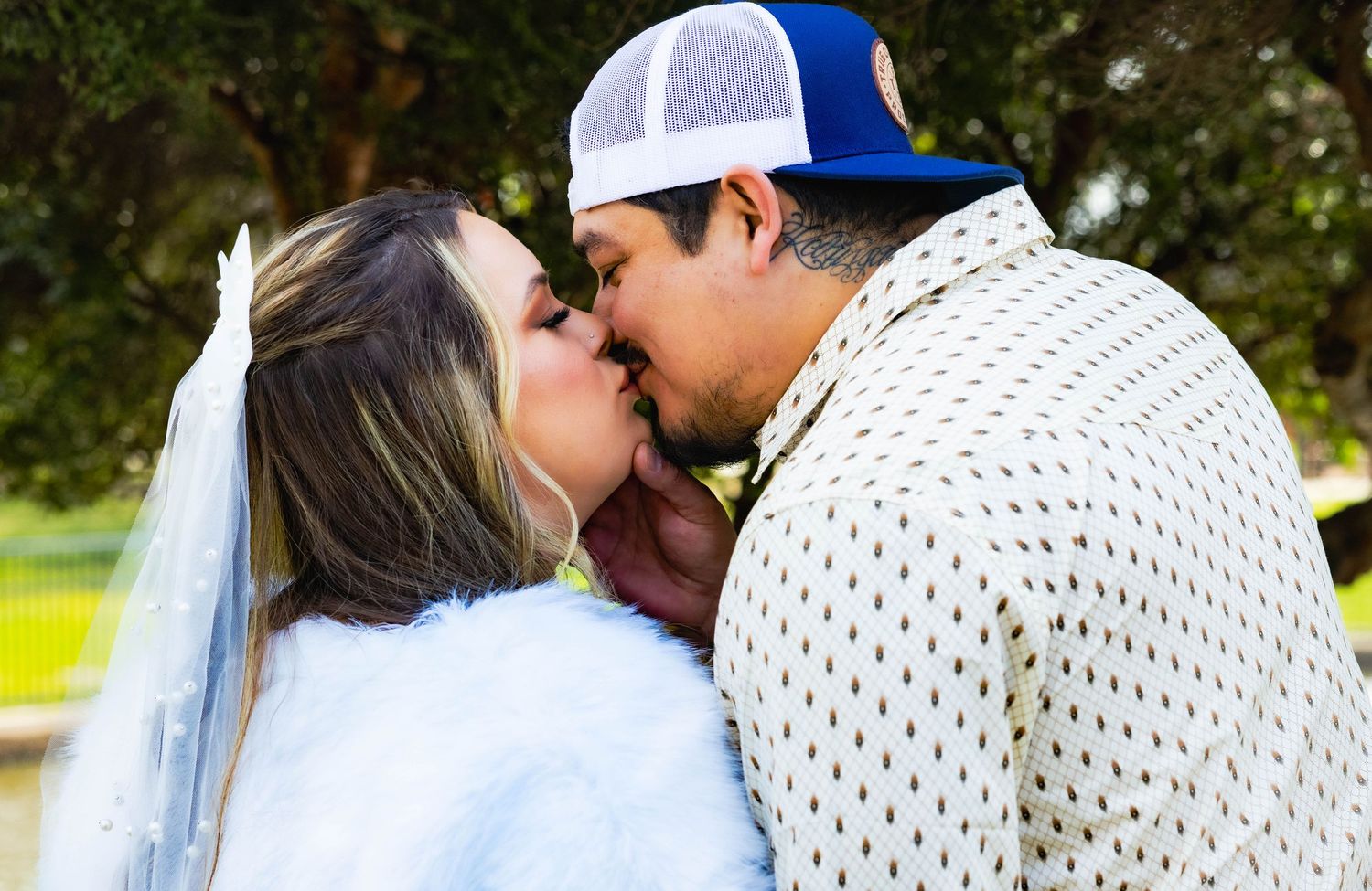 Intimate moment between newlyweds in casual wedding attire outdoors in Stockton by lake, kissing. Lodi, Wedding photographer.