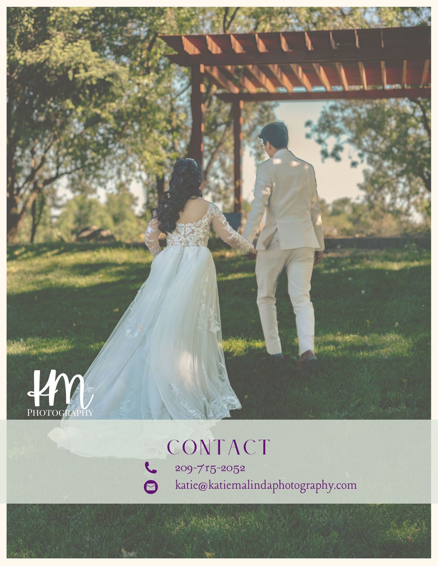 A couple in wedding attire strolls through a sunlit garden with wooden pergolas overhead on their special day.