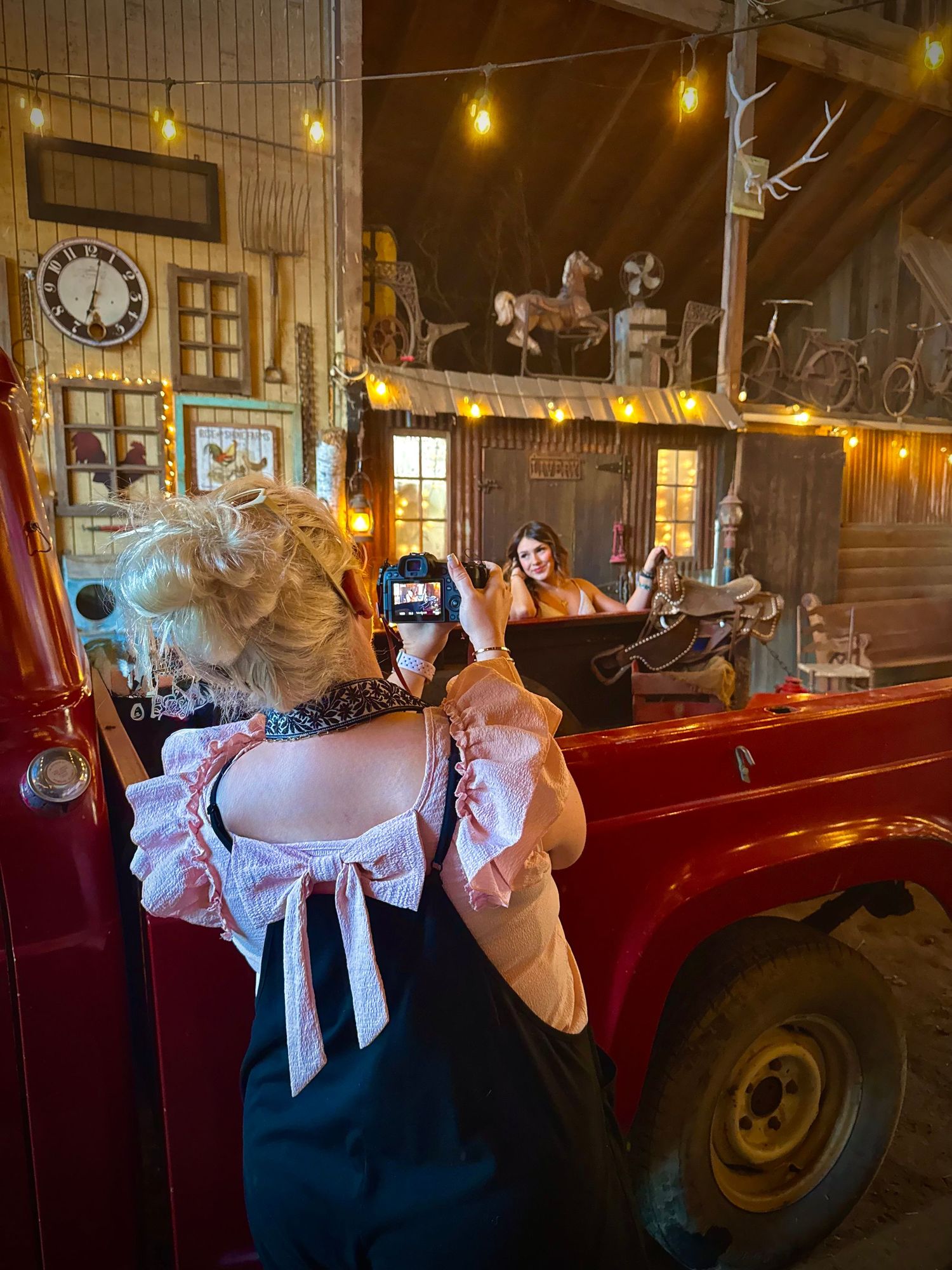 A series of vintage-style photos showing a person in a blue dress posing with a classic red truck in a rustic barn setting.