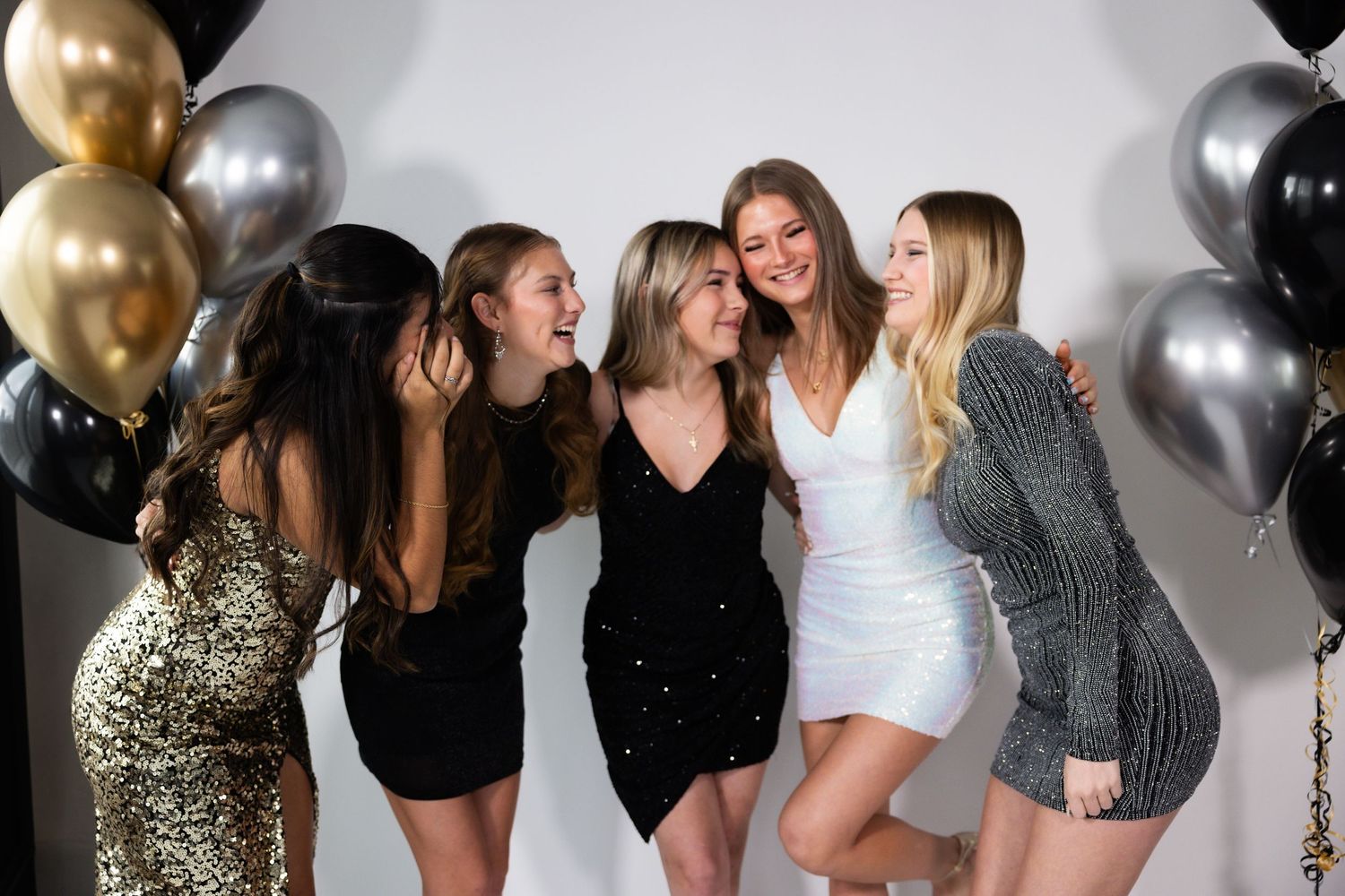 Friends celebrating at a party with black and gold balloon decorations in Stockton.