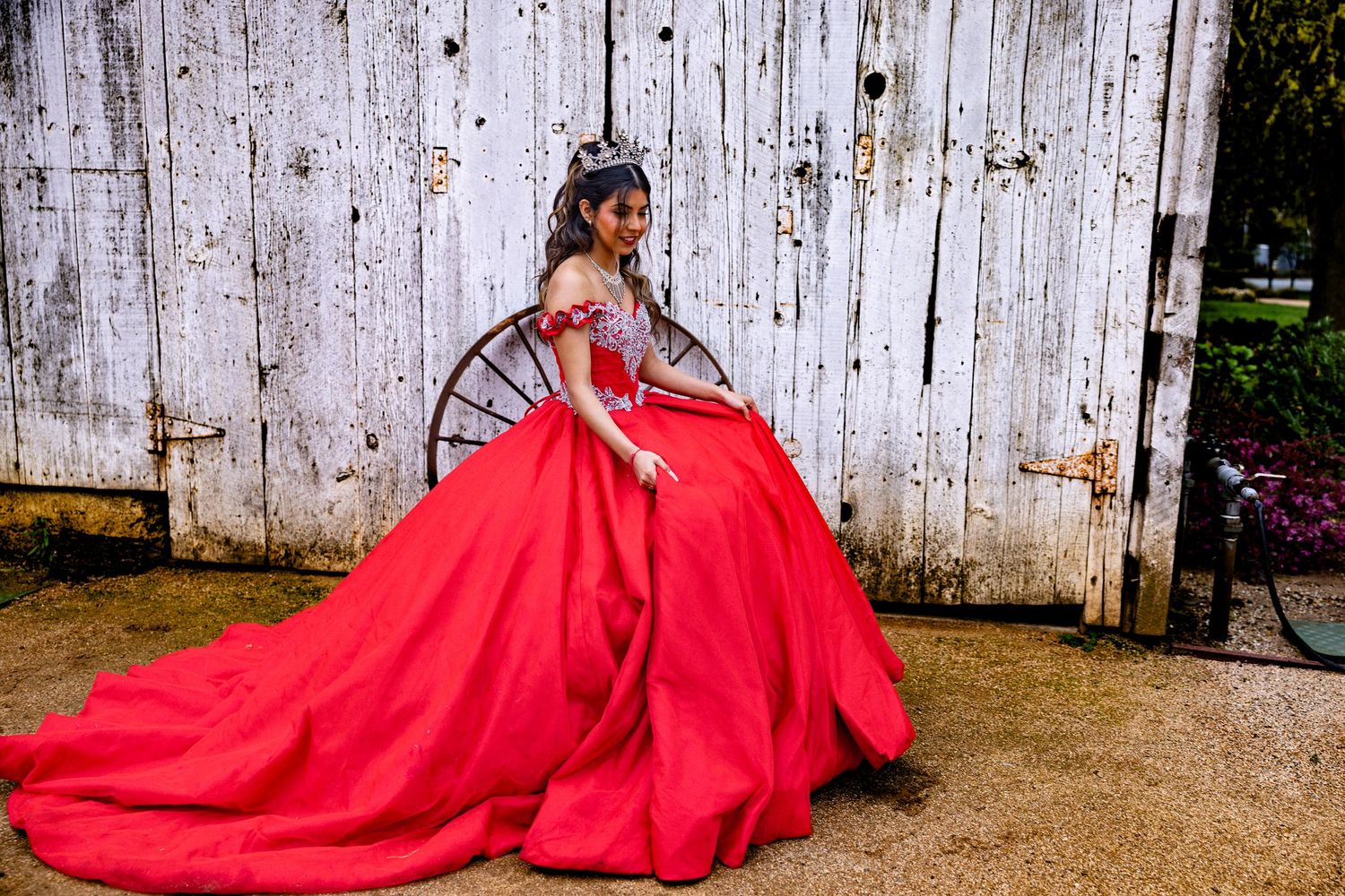 Lodi quinceañera in a red gown and crown, captured by Katie Malinda. Elegant, regal, and timeless portrait in a lush outdoor setting.