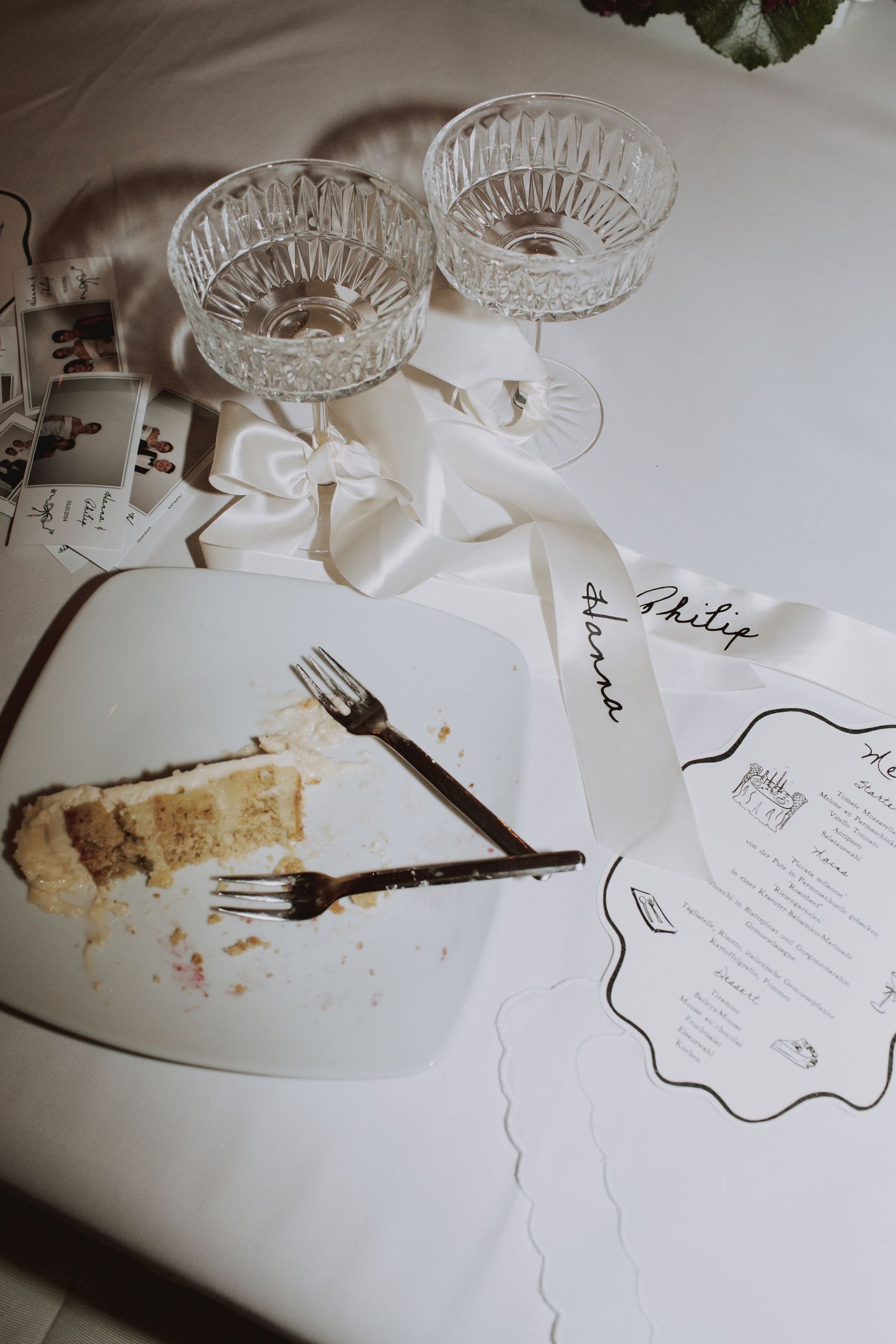 Wedding reception place setting with crystal glasses and menu card.