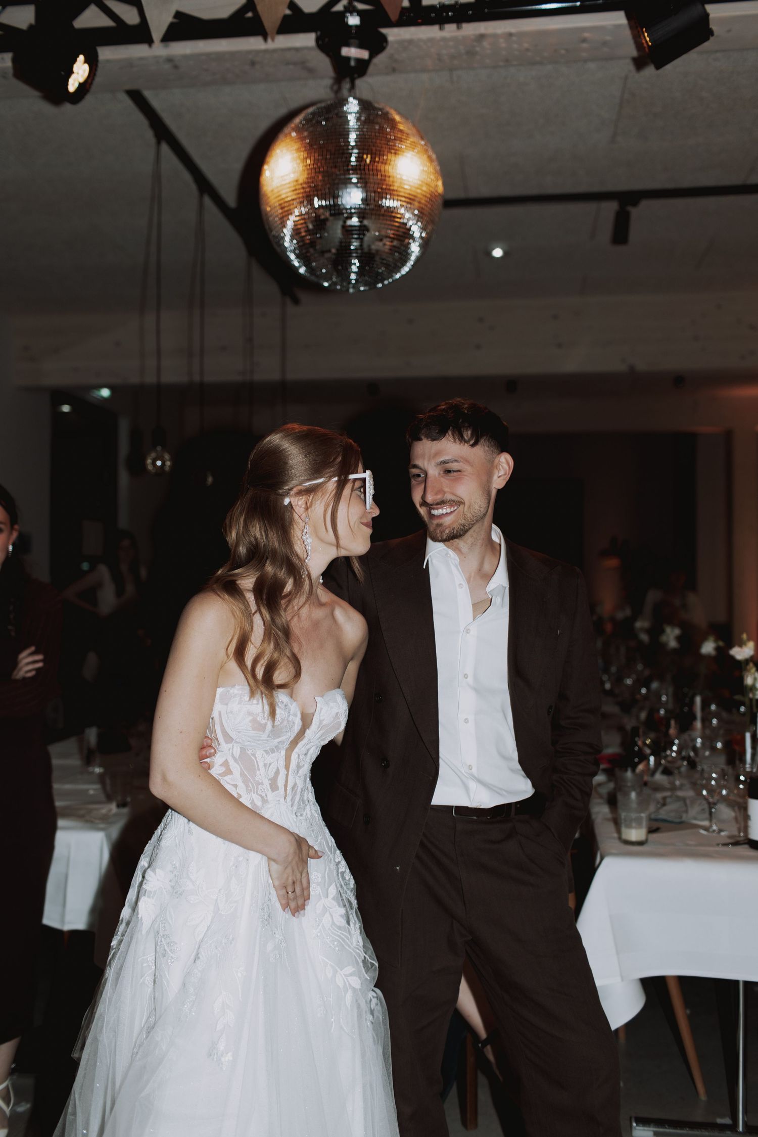 A romantic dance sequence under disco balls at an elegant wedding reception.