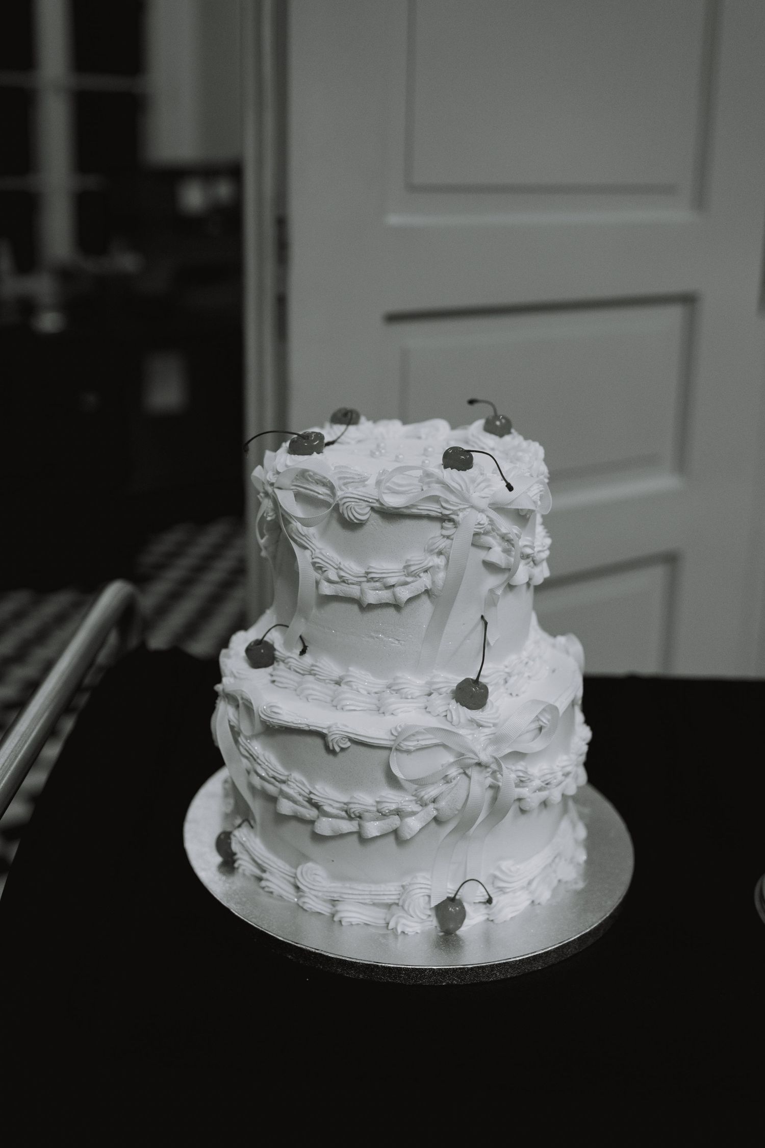 Elegant white wedding cake with textured frosting layers displayed at reception.