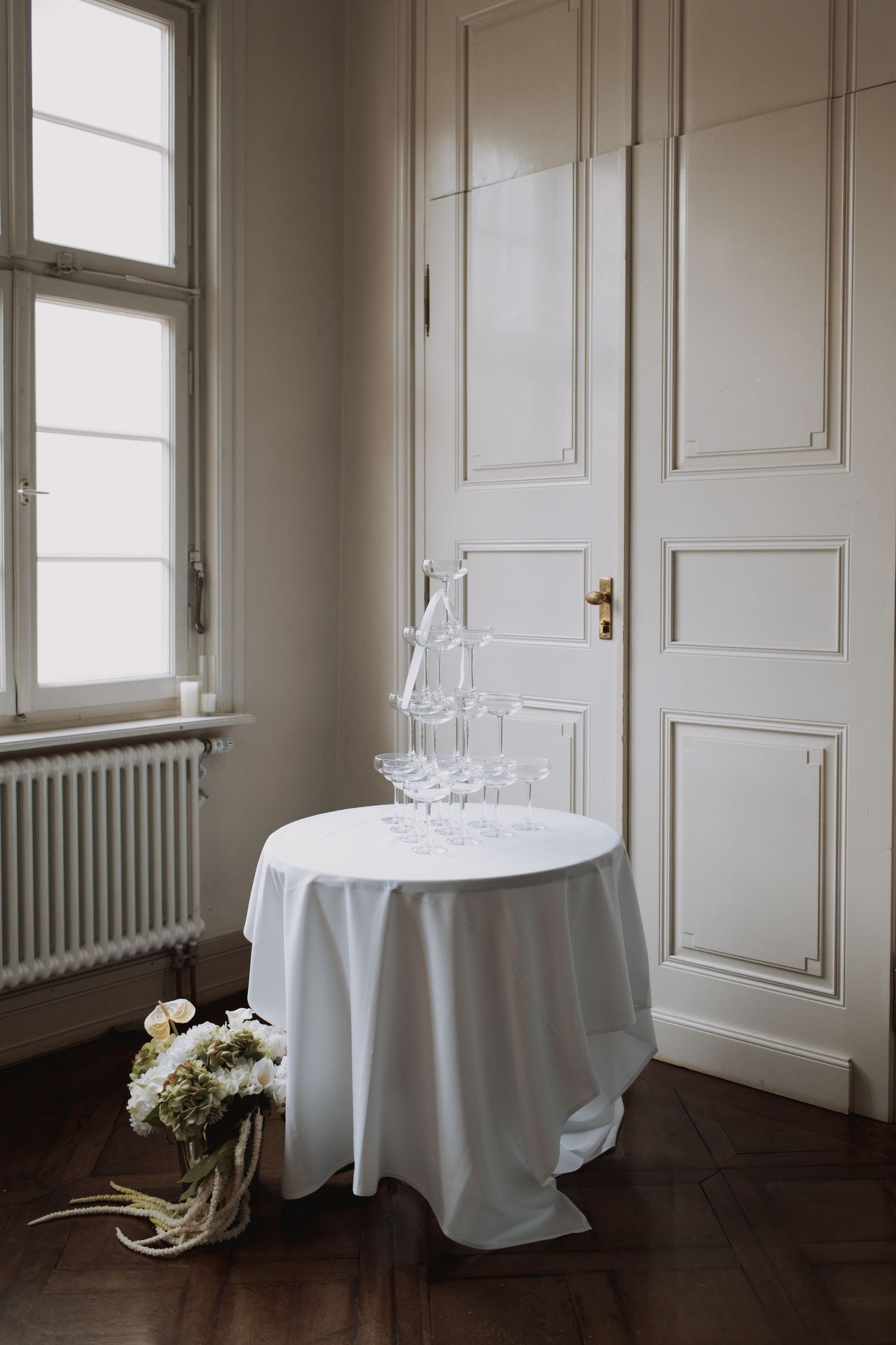 Minimalist room interior with white tablecloths and elegant floral arrangements.
