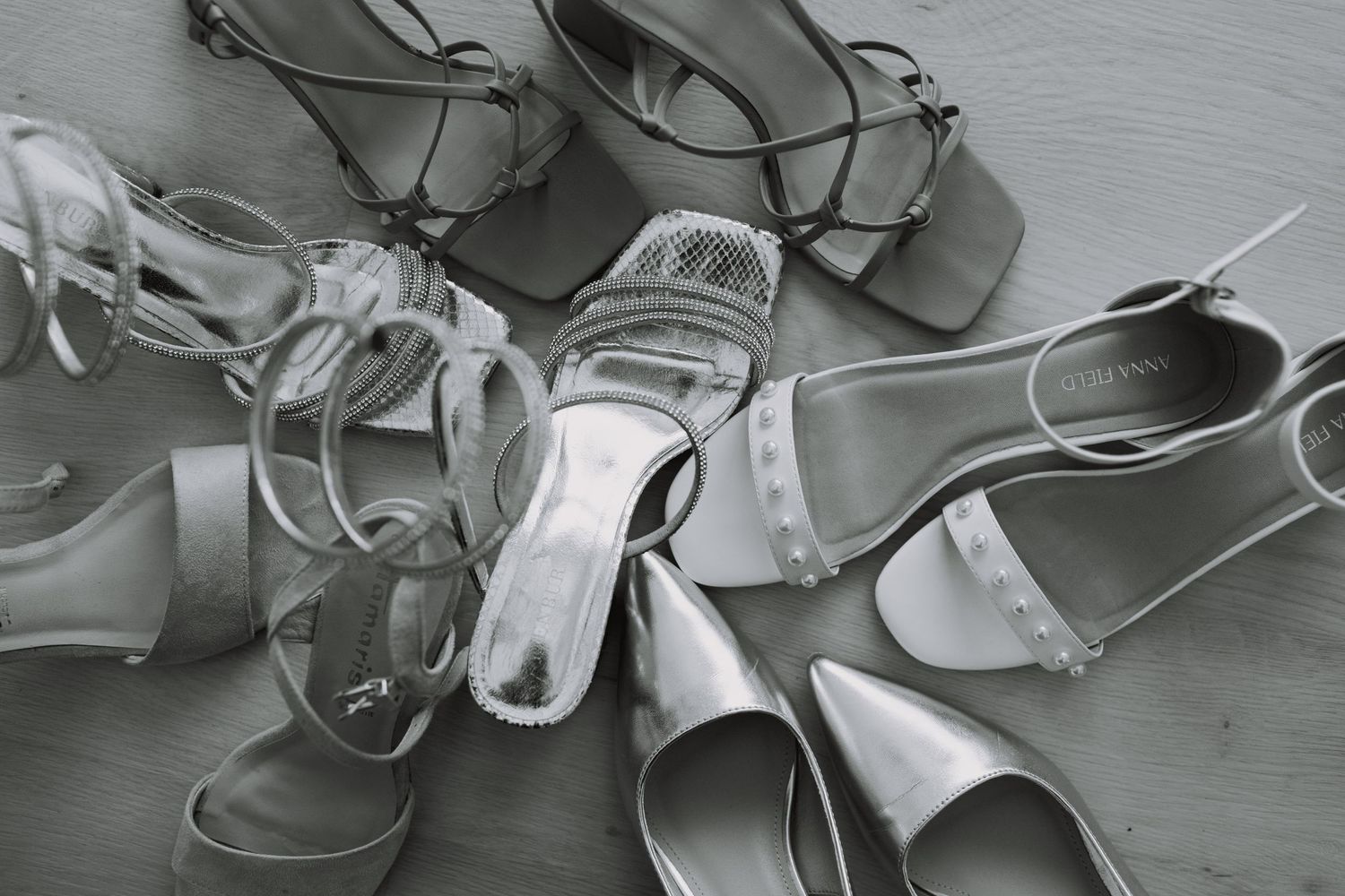 A black and white photo showing discarded ballet pointe shoes scattered across a floor.