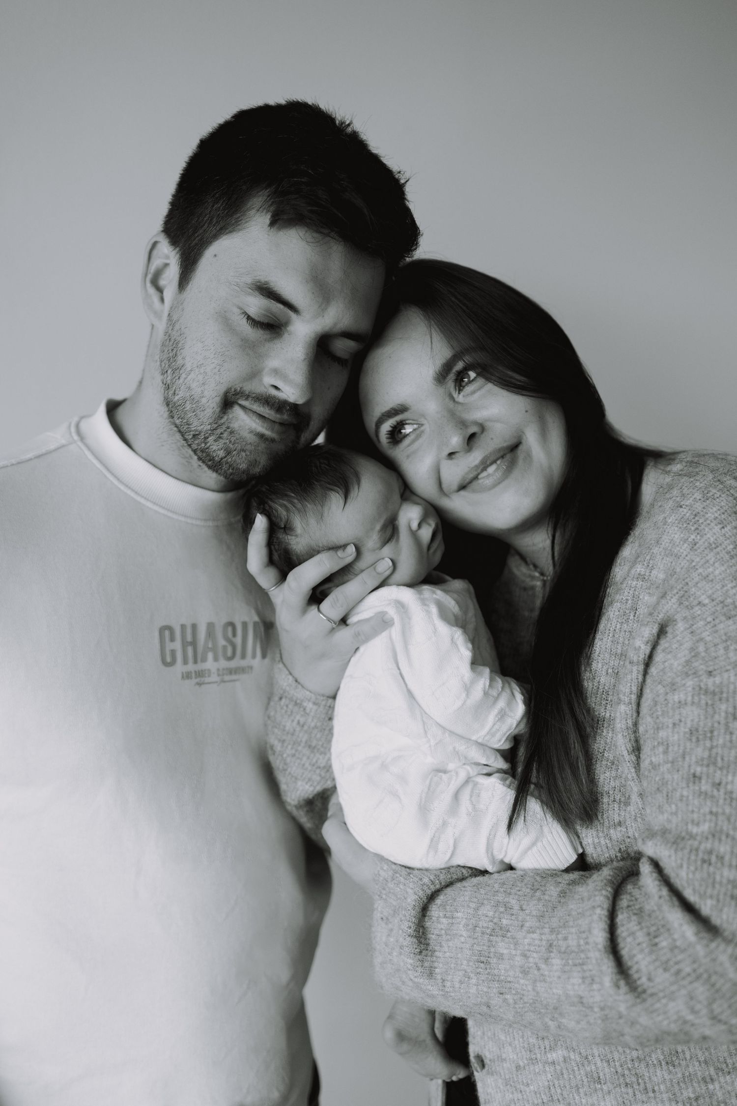 Black and white intimate family portrait series showing tender moments and cuddles.