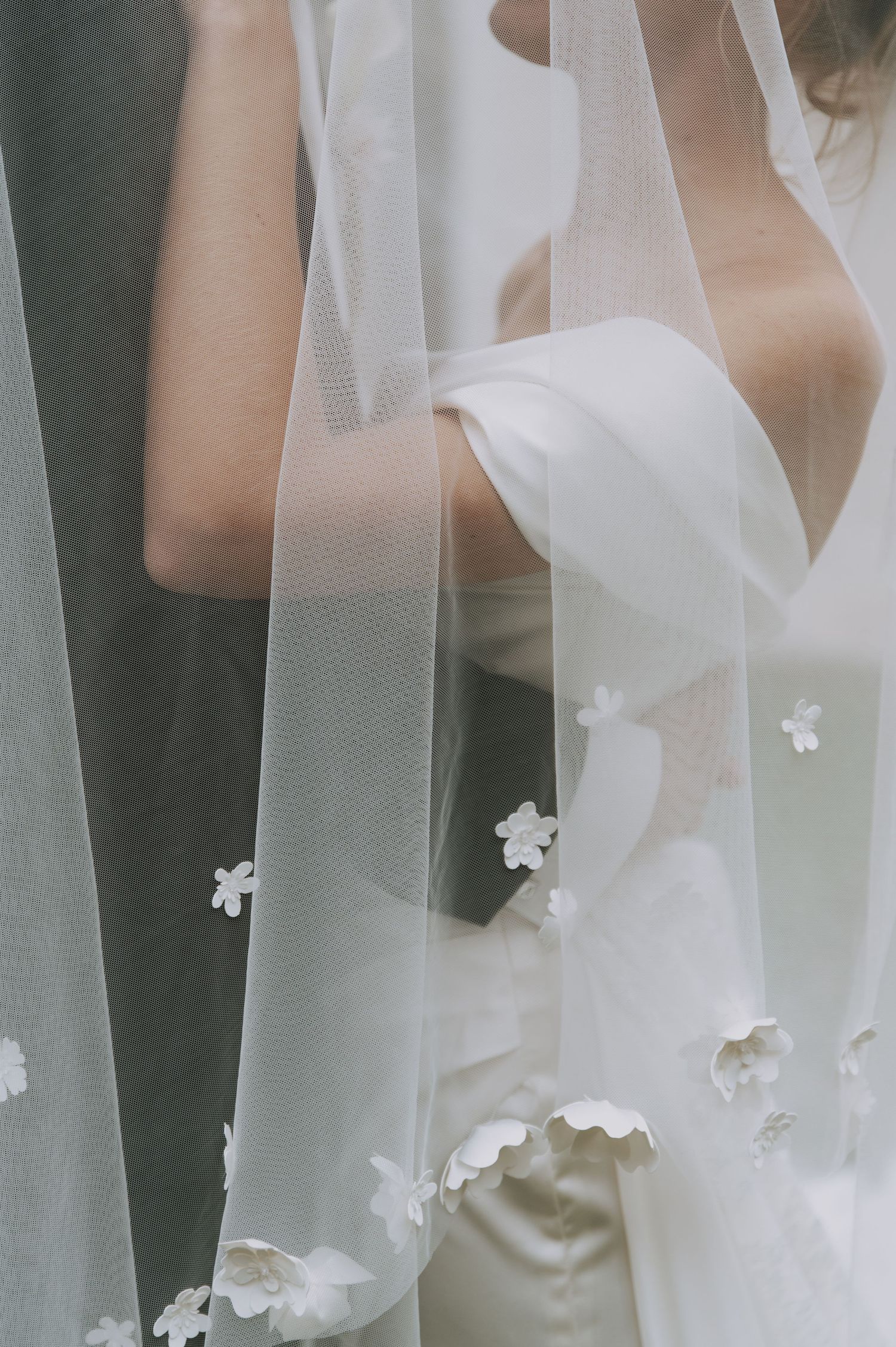 Close-up of delicate white veil with floral appliques in soft natural light.