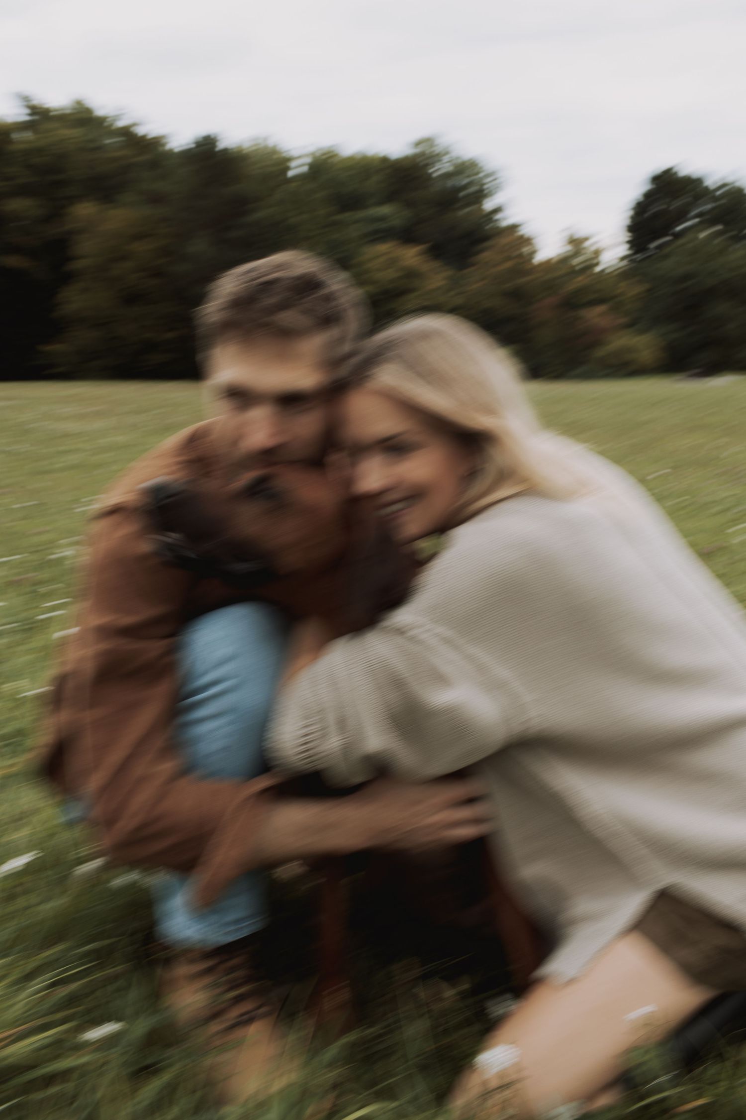 A sequence of motion-blurred photos showing people embracing outdoors in a grassy field.