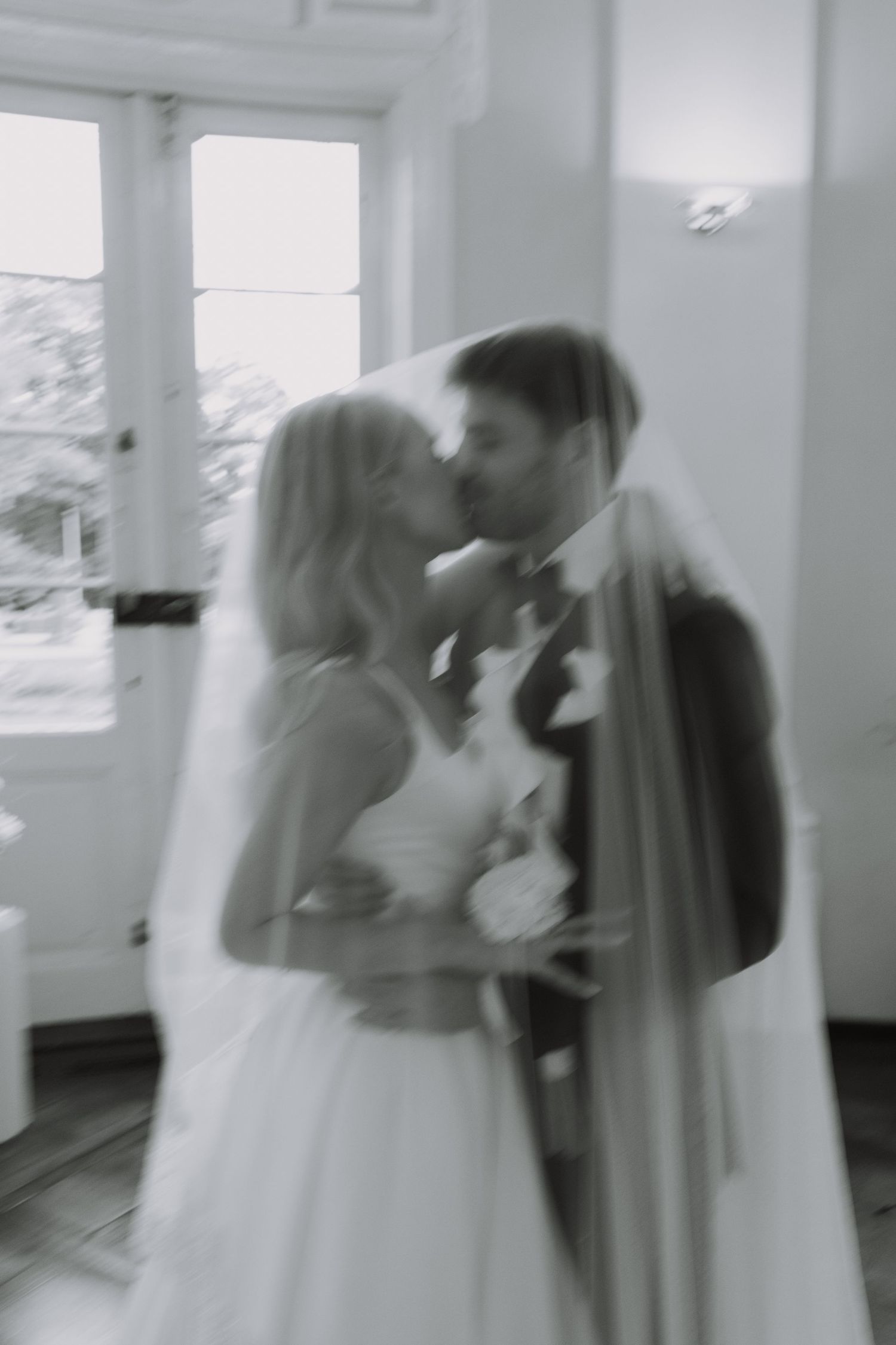 Ethereal wedding moment captured in soft, blurred black and white photography.