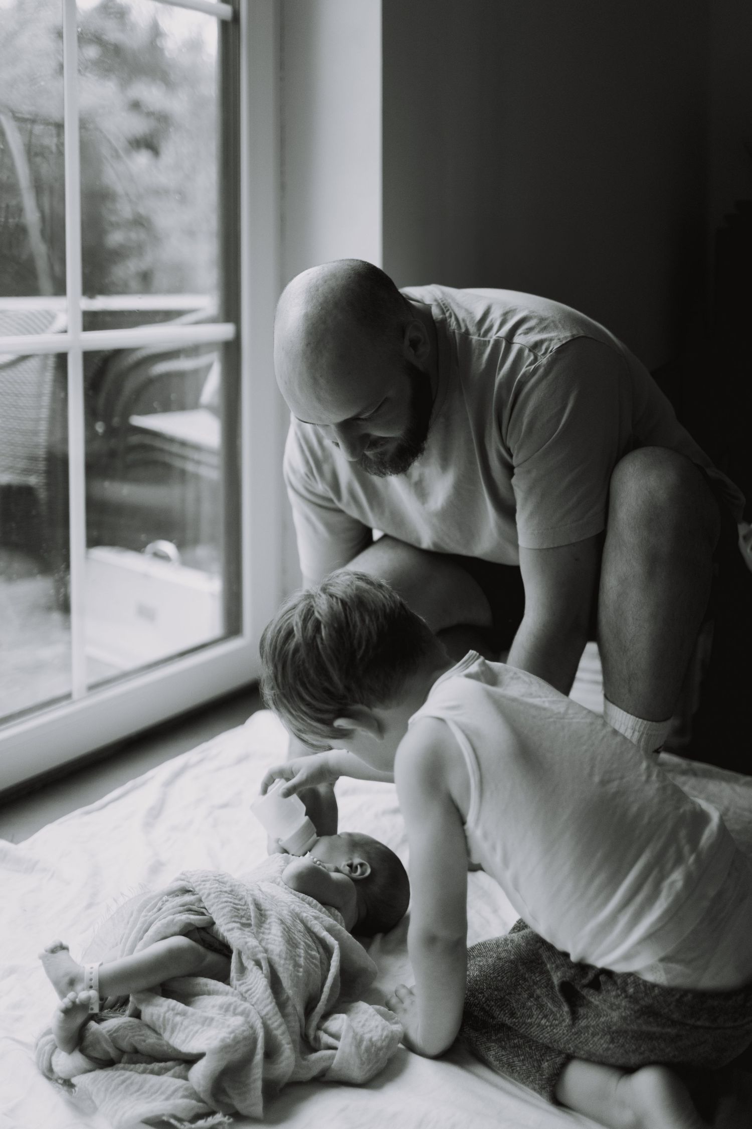 Black and white series capturing intimate moments by a window.