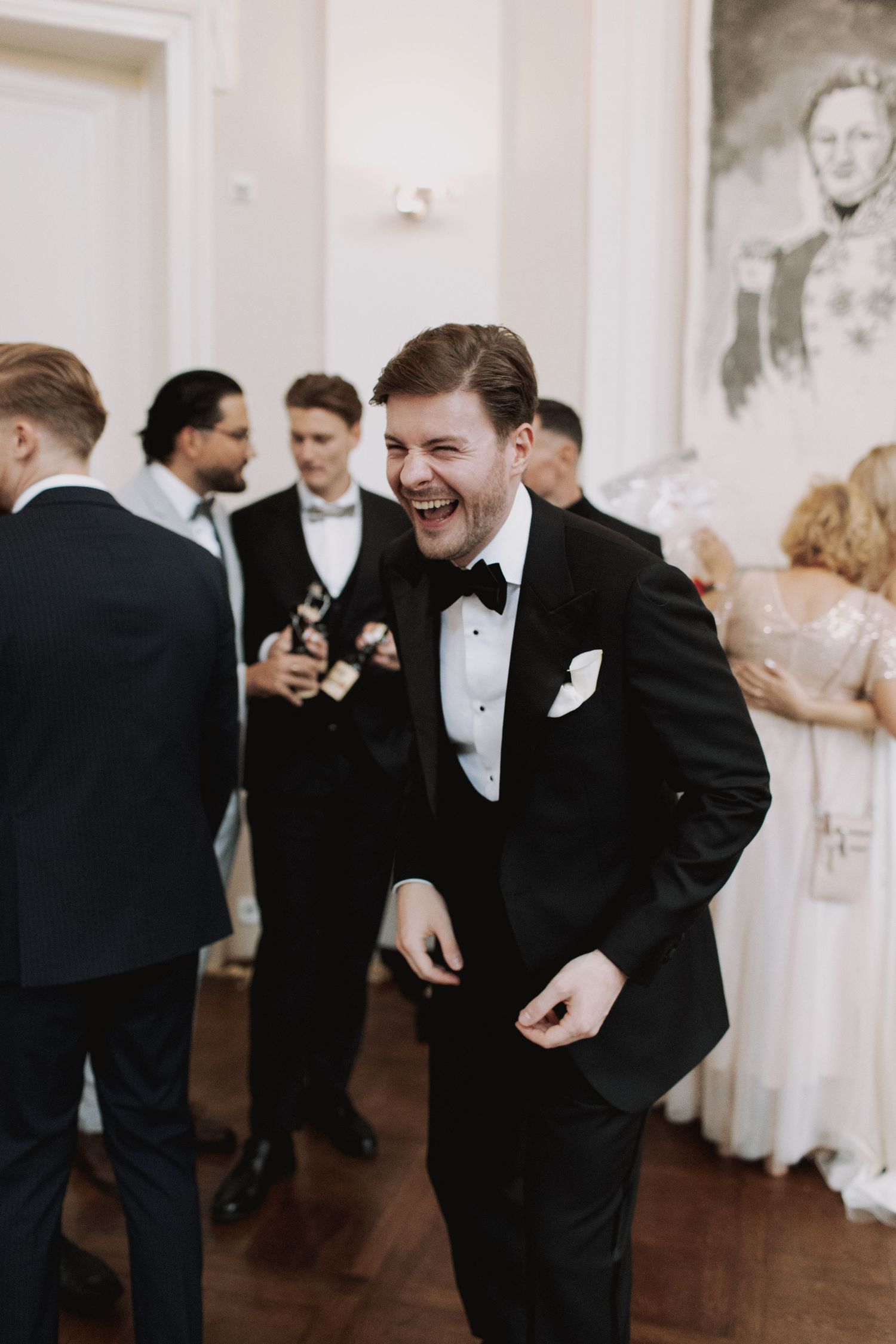Wedding guests in formal attire dancing and celebrating at an elegant indoor reception.