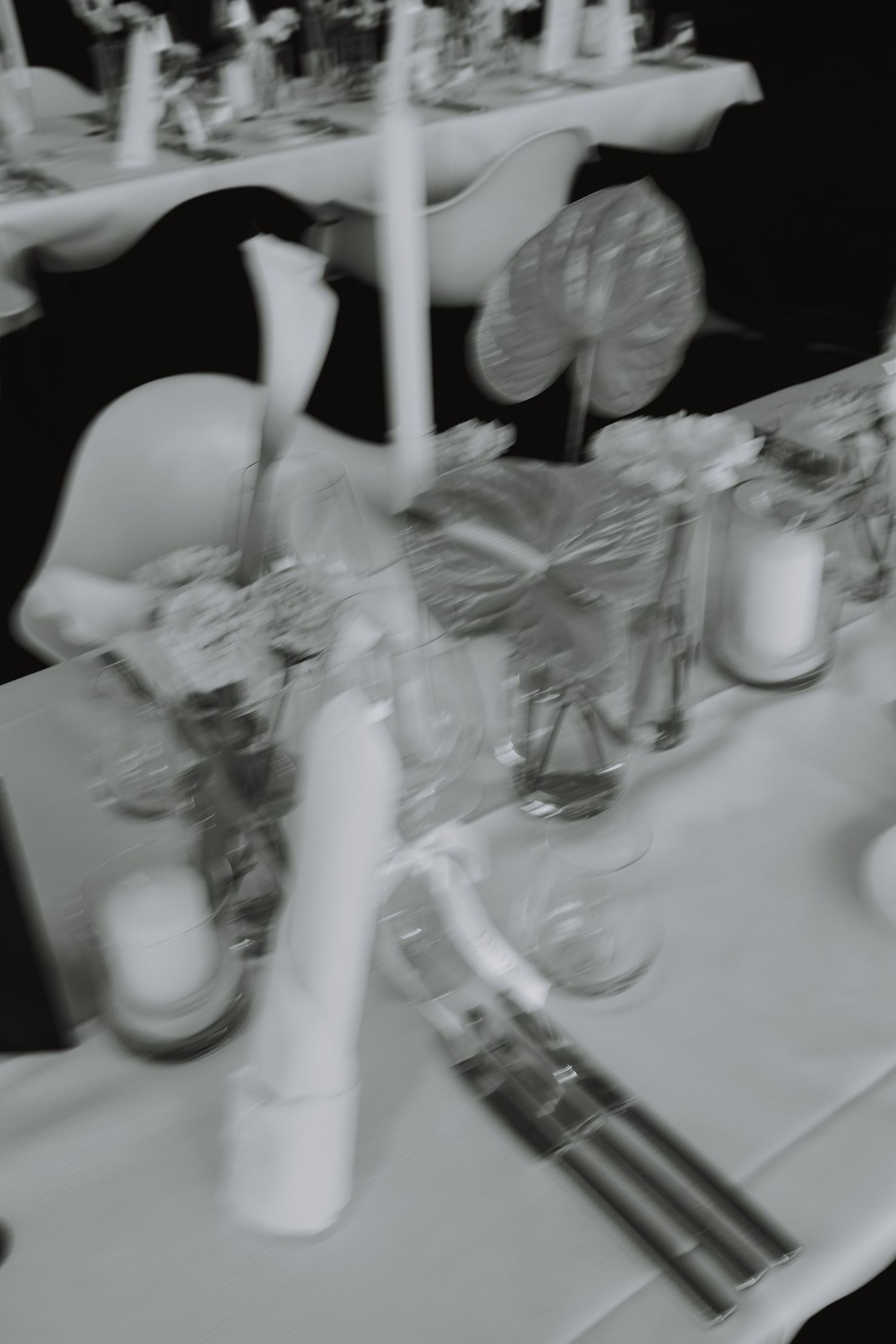 Elegant table setting with white candles and glassware at a formal event.