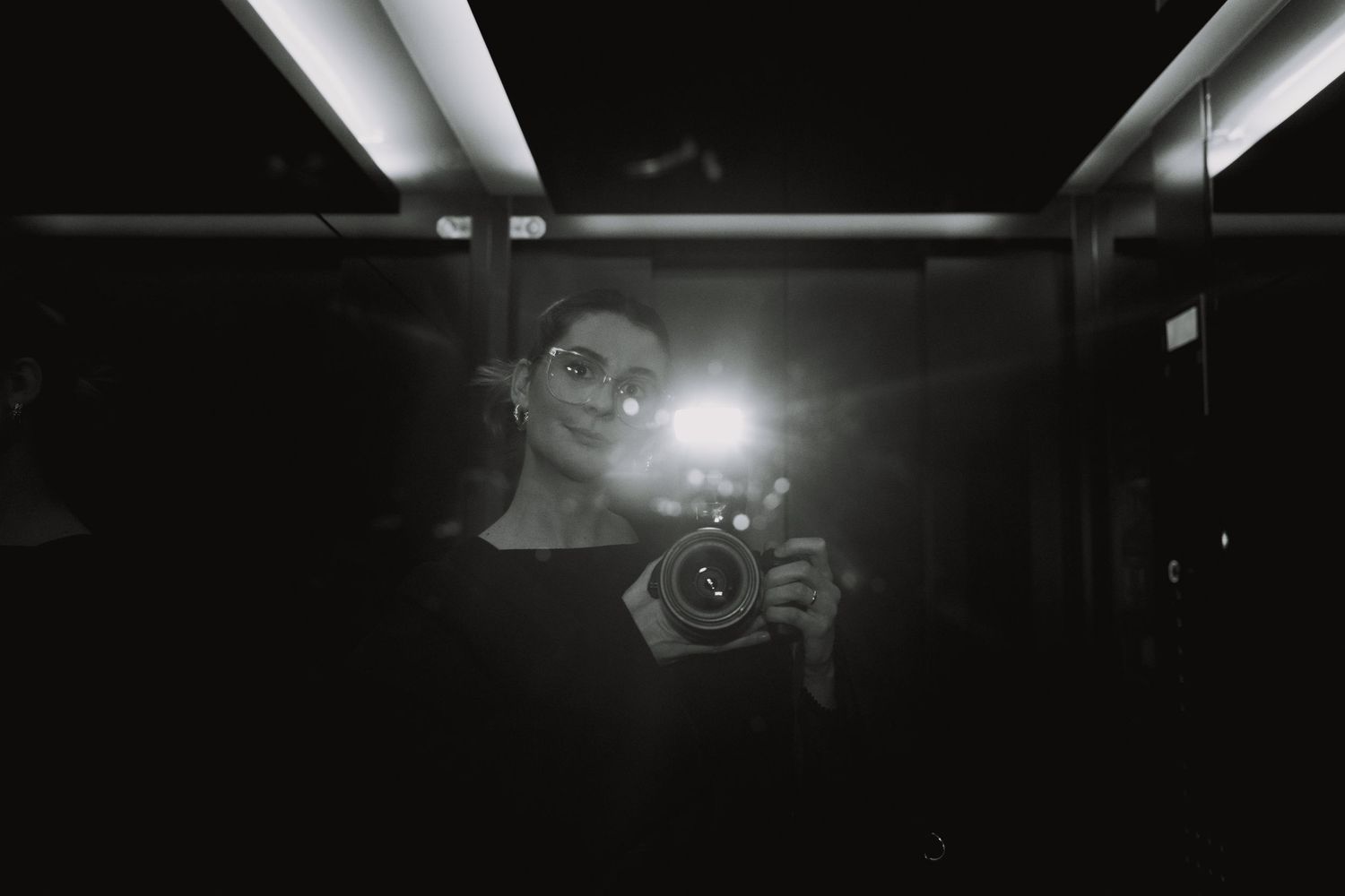 Series of reflective self-portraits in dark space with camera equipment.