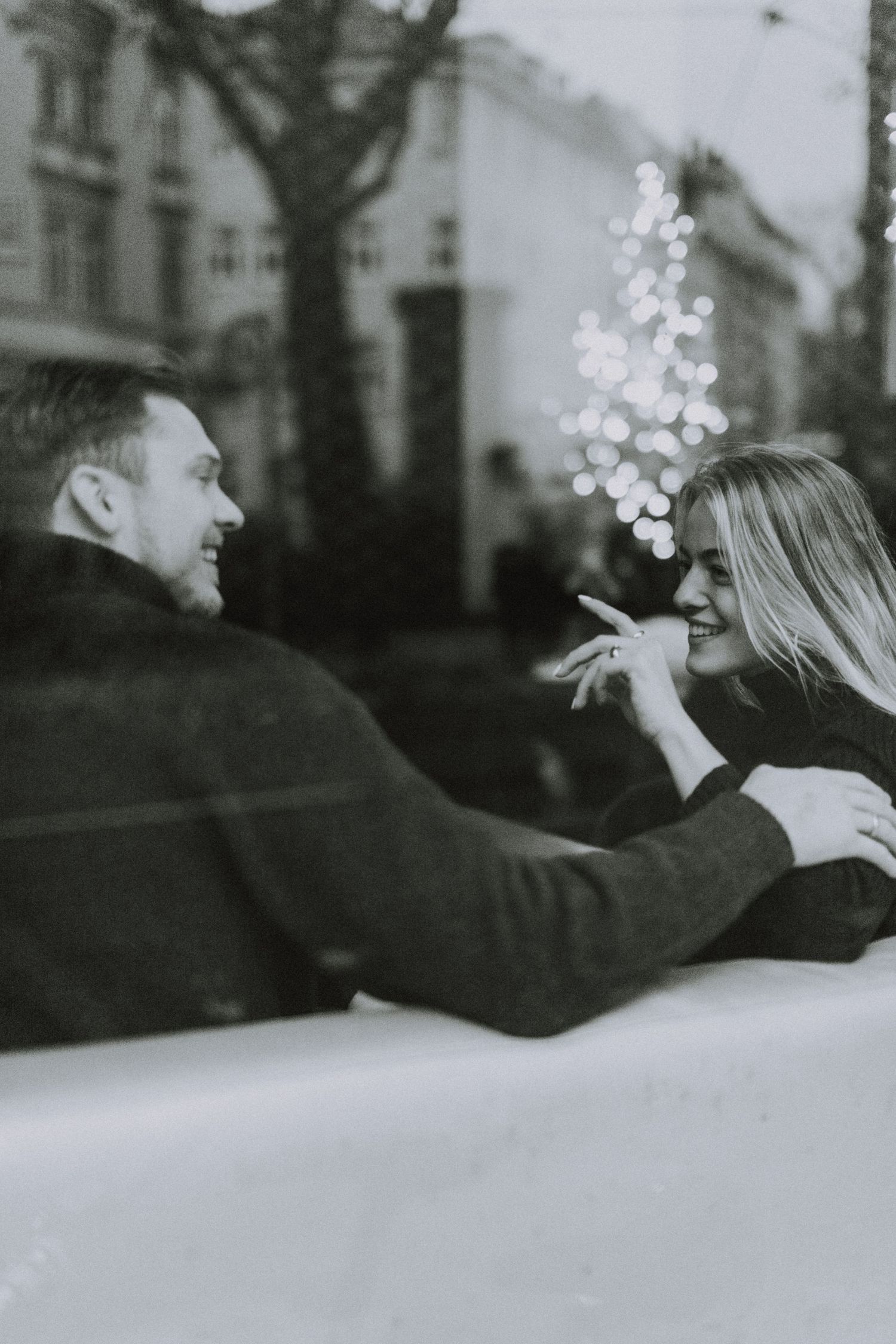 A black and white sequence of photos showing two people blowing snow at each other in a playful winter moment.