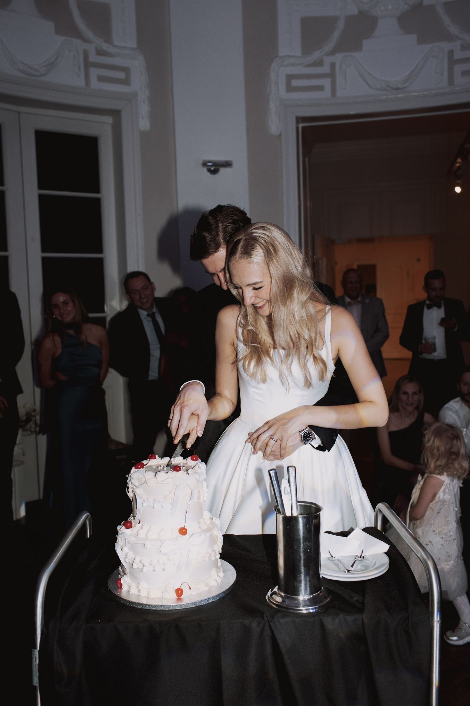 Sequence of a wedding couple playfully smashing cake into each other's faces during their reception celebration.
