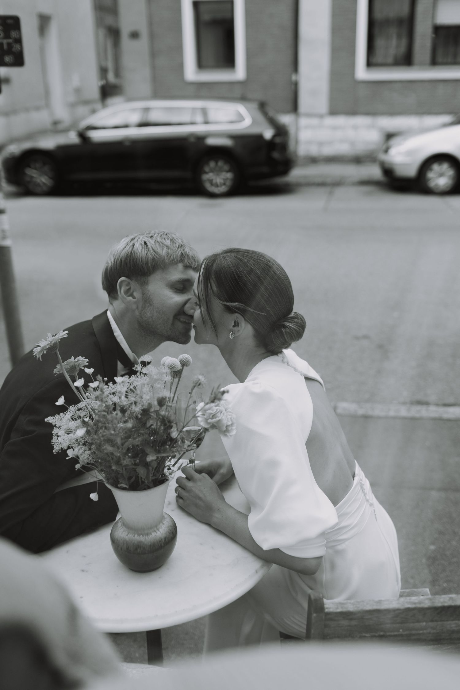 Romantic black and white sequence of couple with flowers on city street.