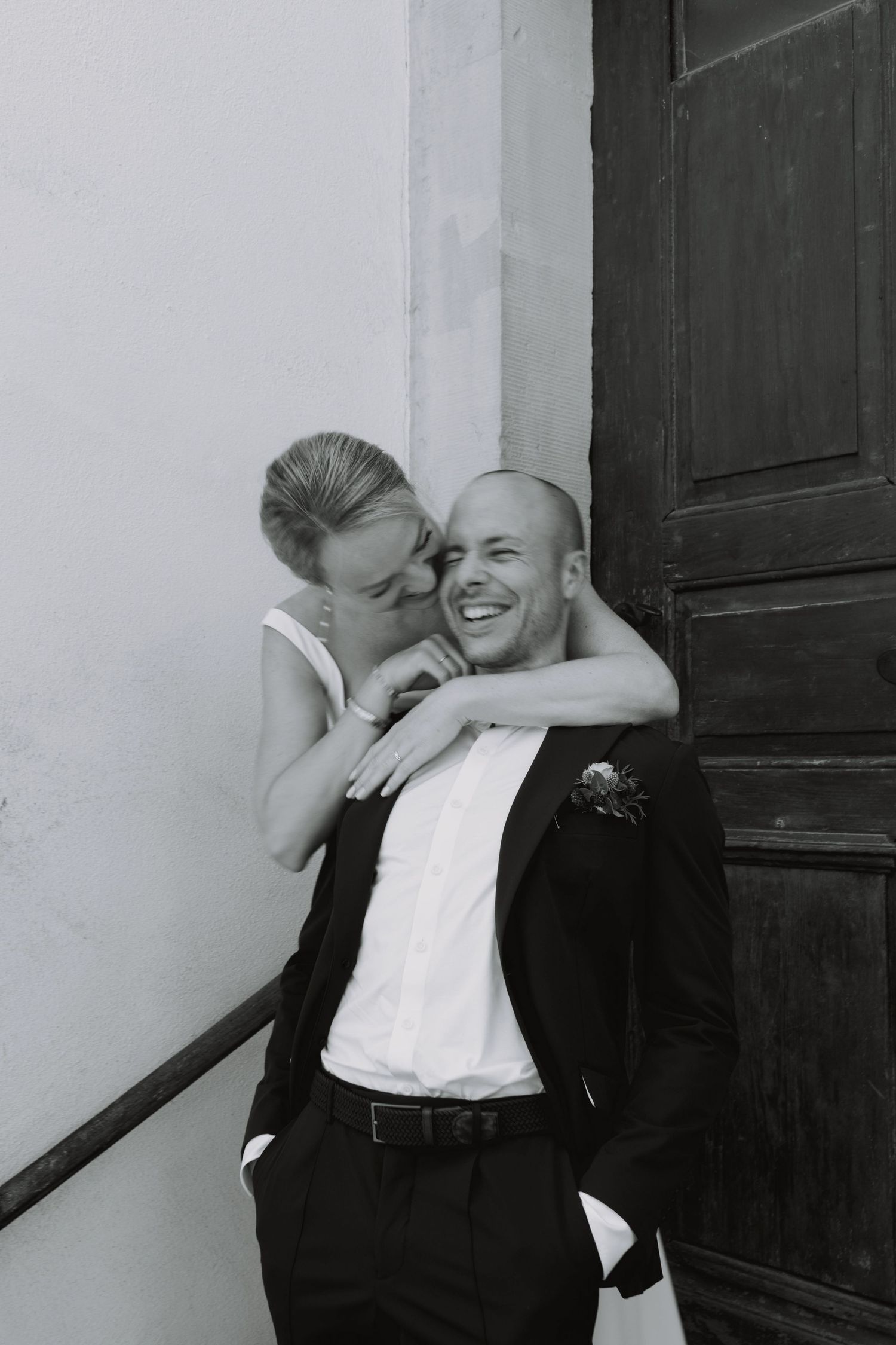 Black and white sequence of intimate wedding couple moments against a dark wall.