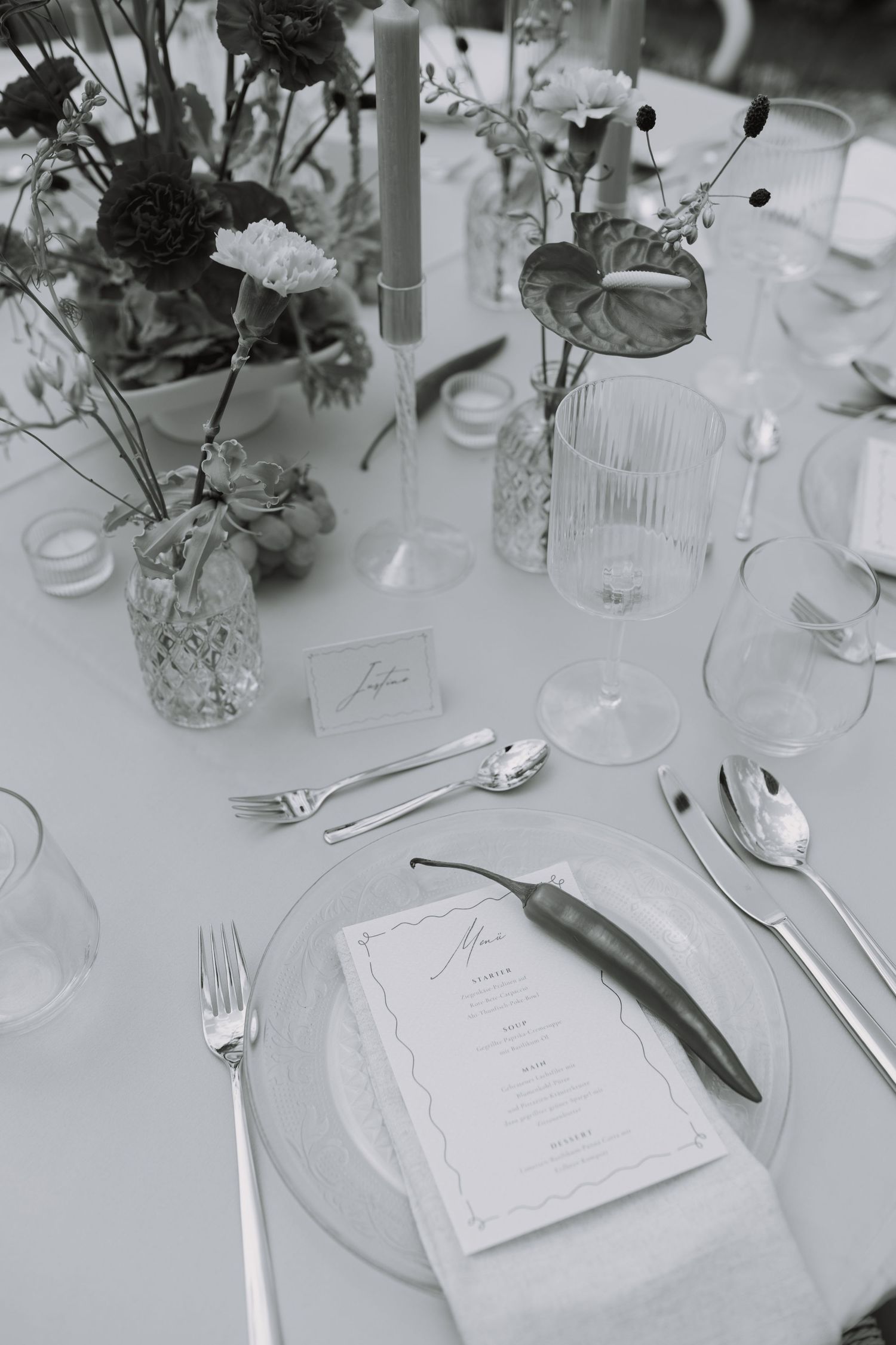 Wedding reception table decorated with floral centerpieces and elegant place settings.
