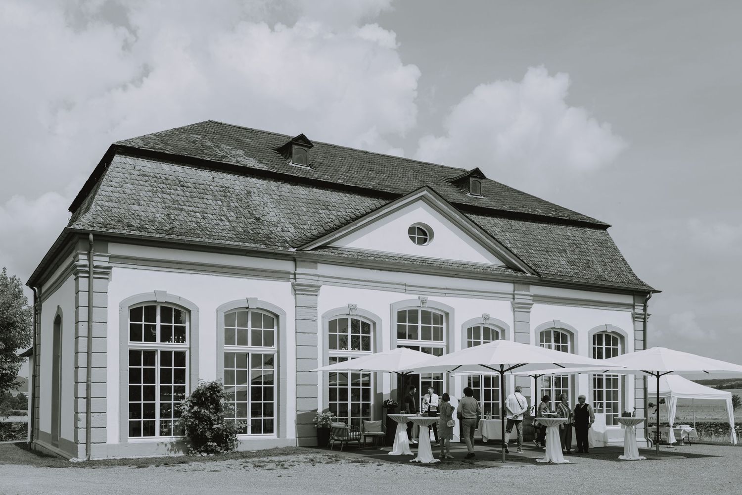 A black and white panoramic photograph of a gas station with white buildings and multiple service bays.