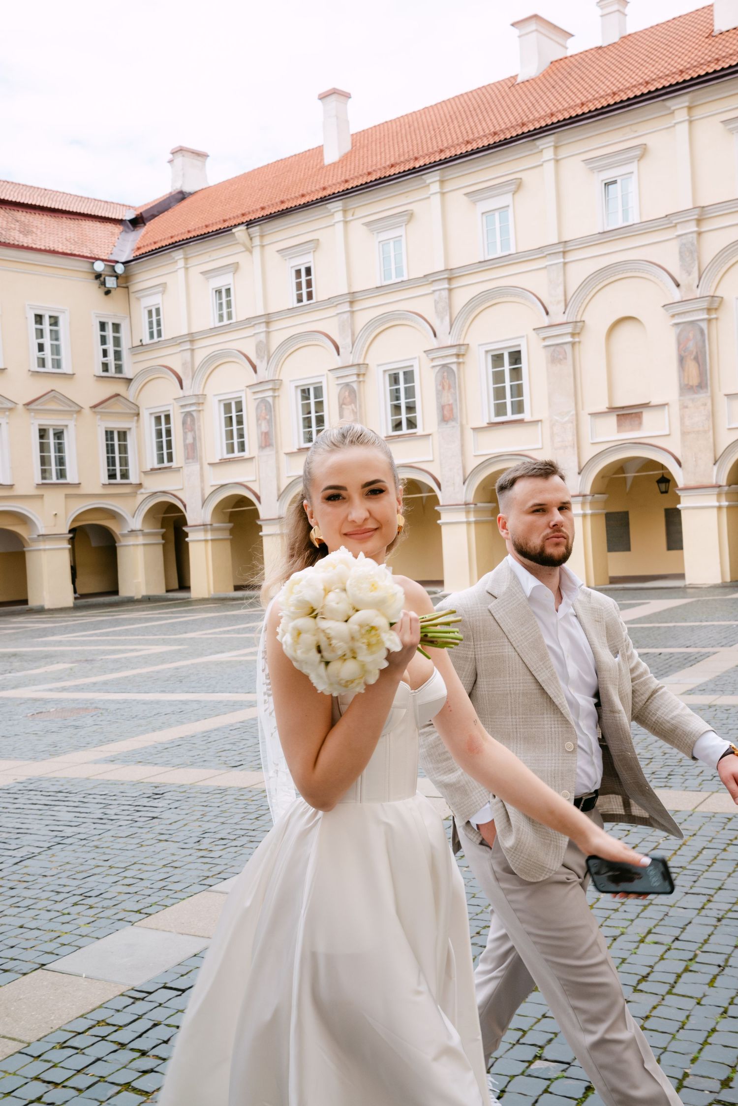 nuotaka ir jaunikis eina kartu istorinėje aikštėje VU kiemelyje