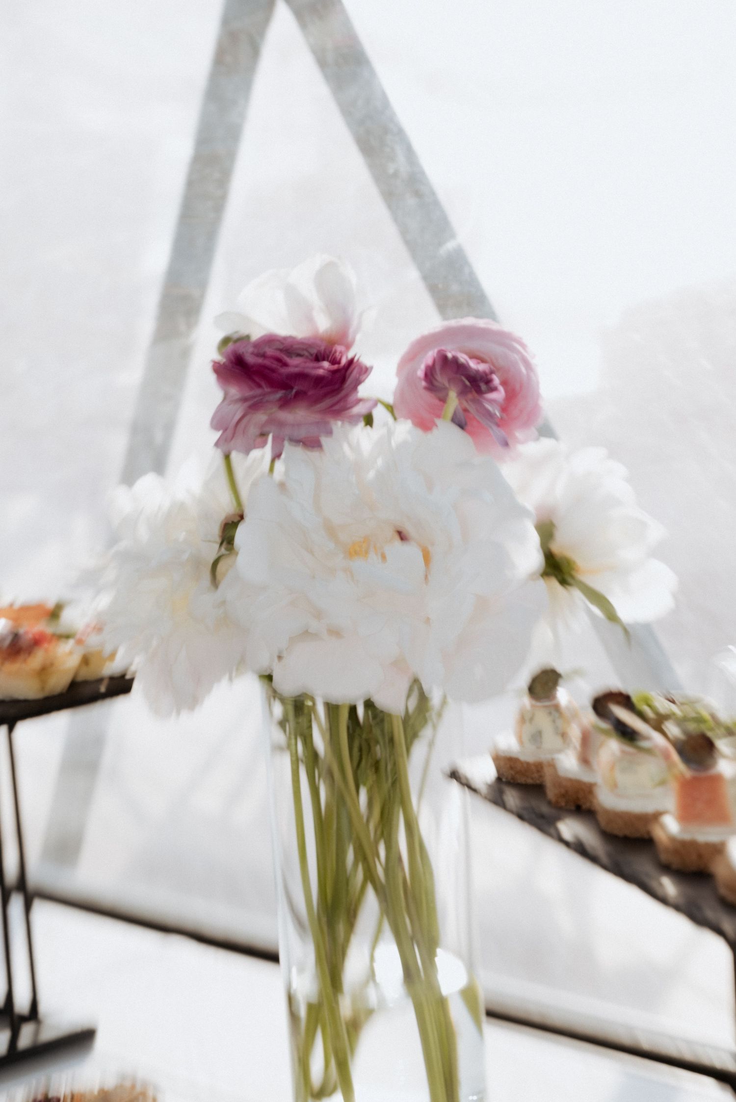 Wedding bouquet with pink and white flowers displayed in front of sailboat masts in Klaipėda, Lithuania.