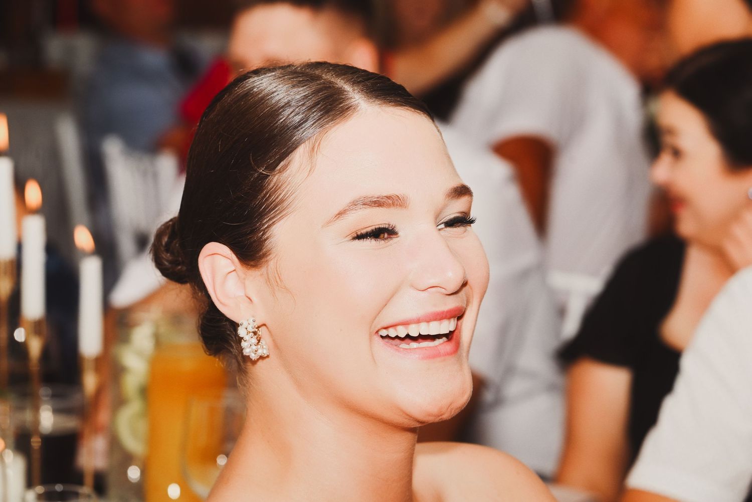 Guest smiling and laughing during the evening celebration, captured candidly in warm light.