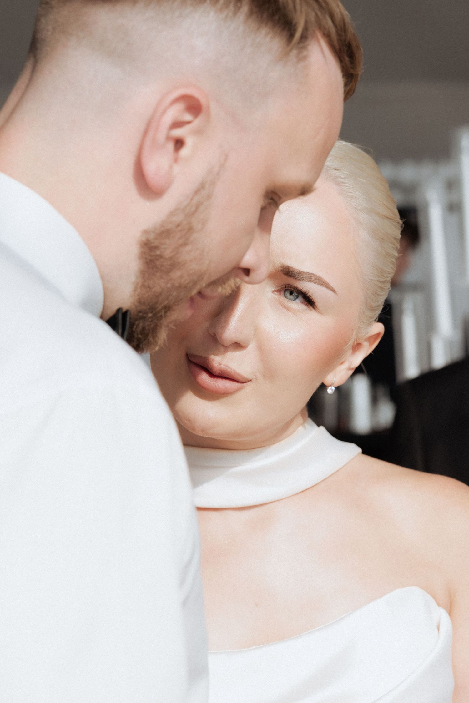 Groom tenderly kissing the bride’s forehead in an intimate moment of love and connection on their wedding day.