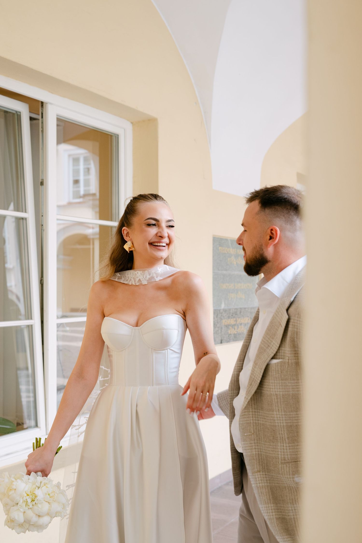 nuotaka ir jaunikis eina kartu elegantiškoje erdvėje susikabinę