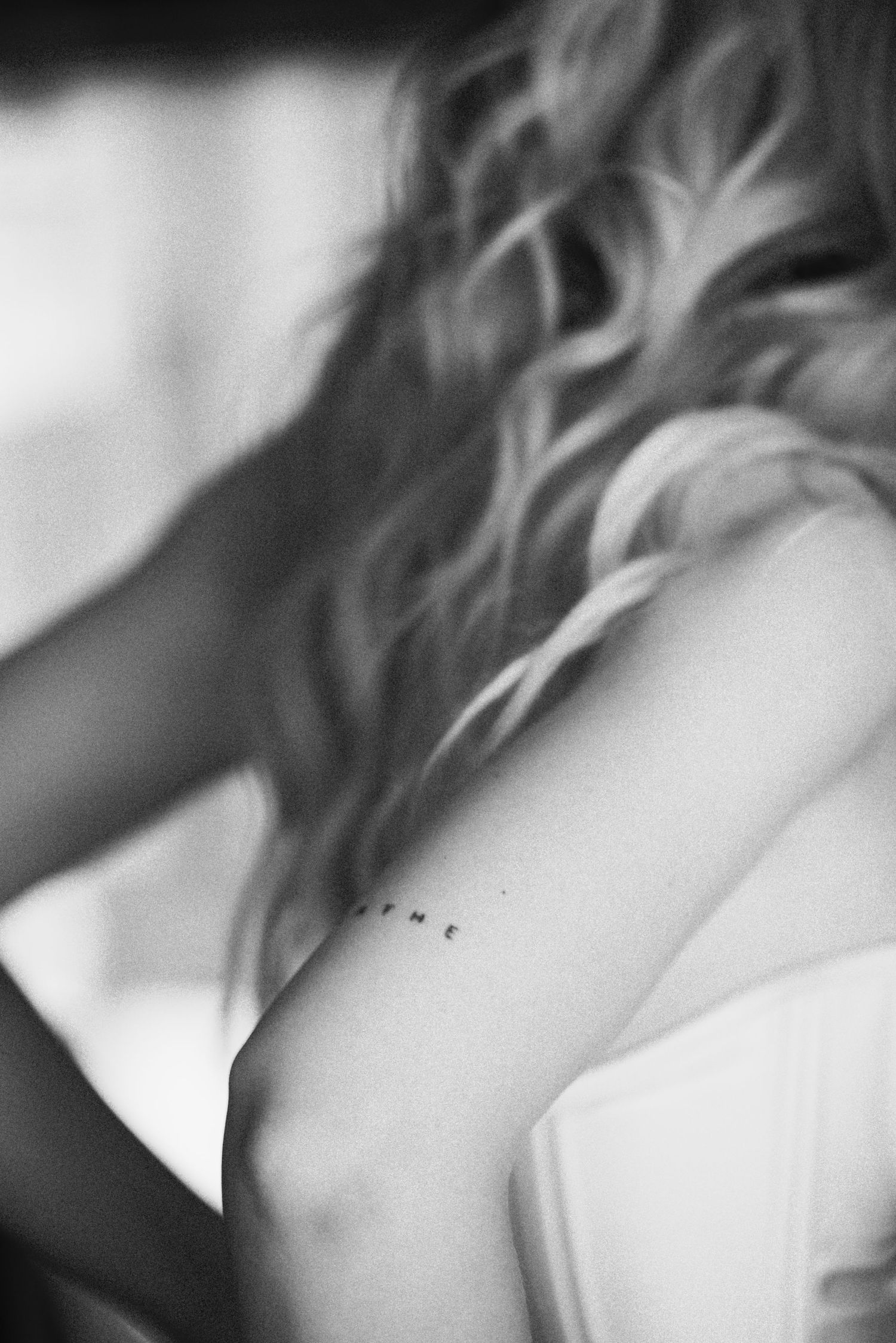 juodai balta detalė, kurioje matosi tatuiruotė ant nuotakos rankos