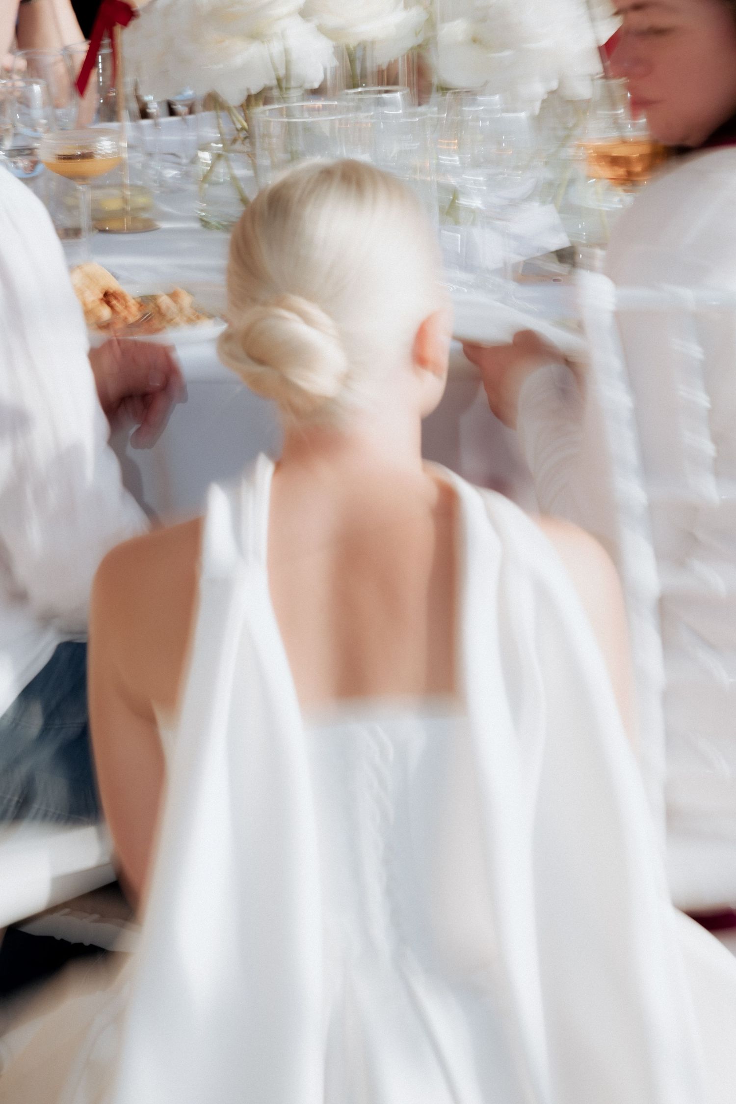 Back view of the bride walking through a sailboat marina, her dress flowing as she moves forward in Klaipėda, Lithuania.