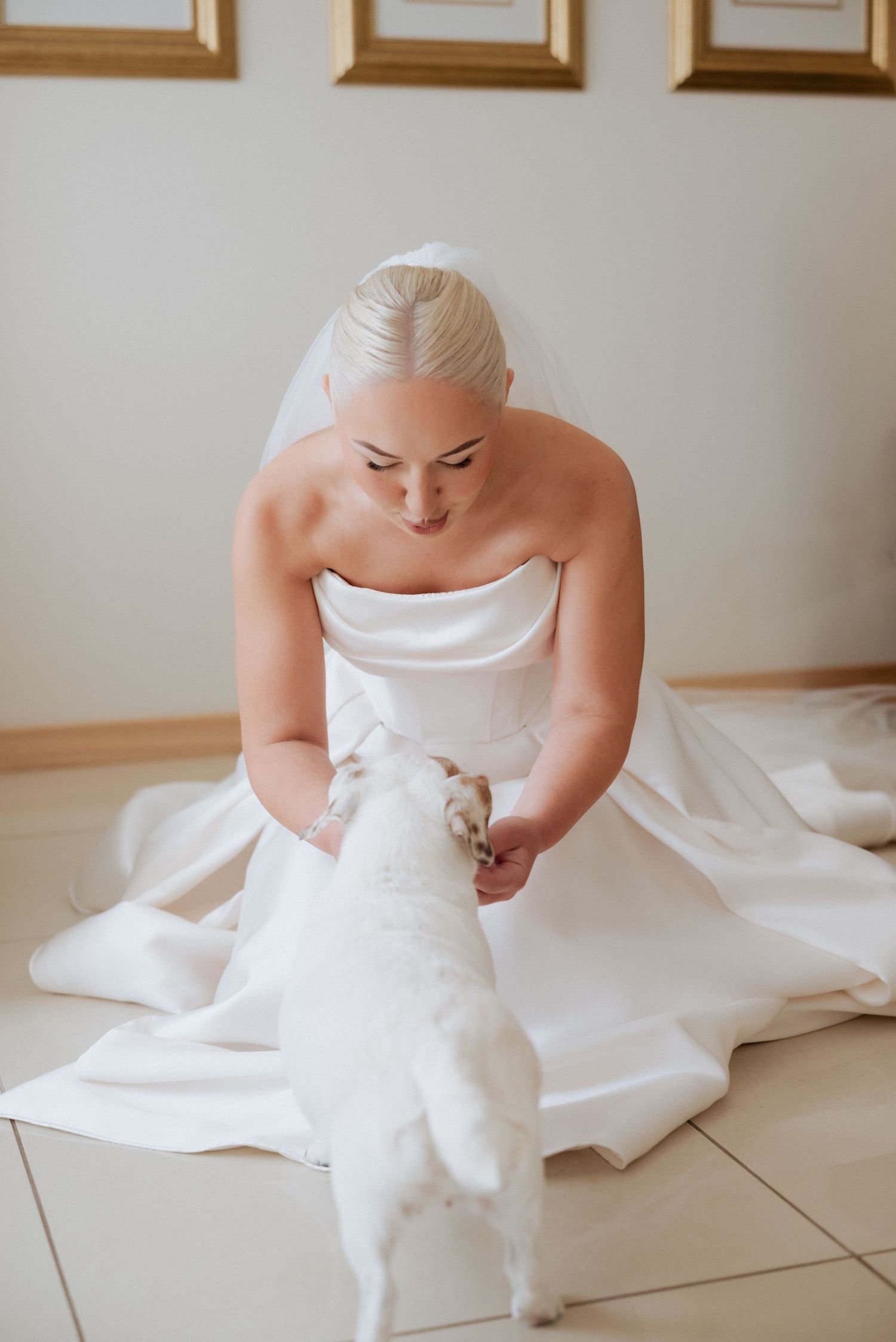 Bride sitting on the floor with a soft smile, captured in a calm and reflective moment before the ceremony.