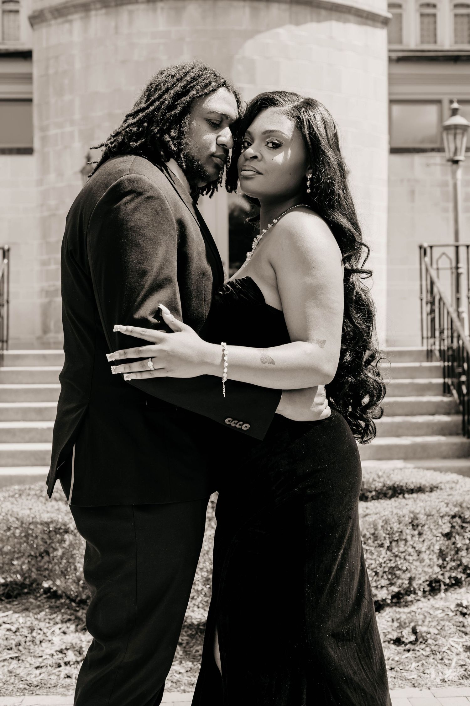 An intimate black and white portrait of a couple in formal attire.