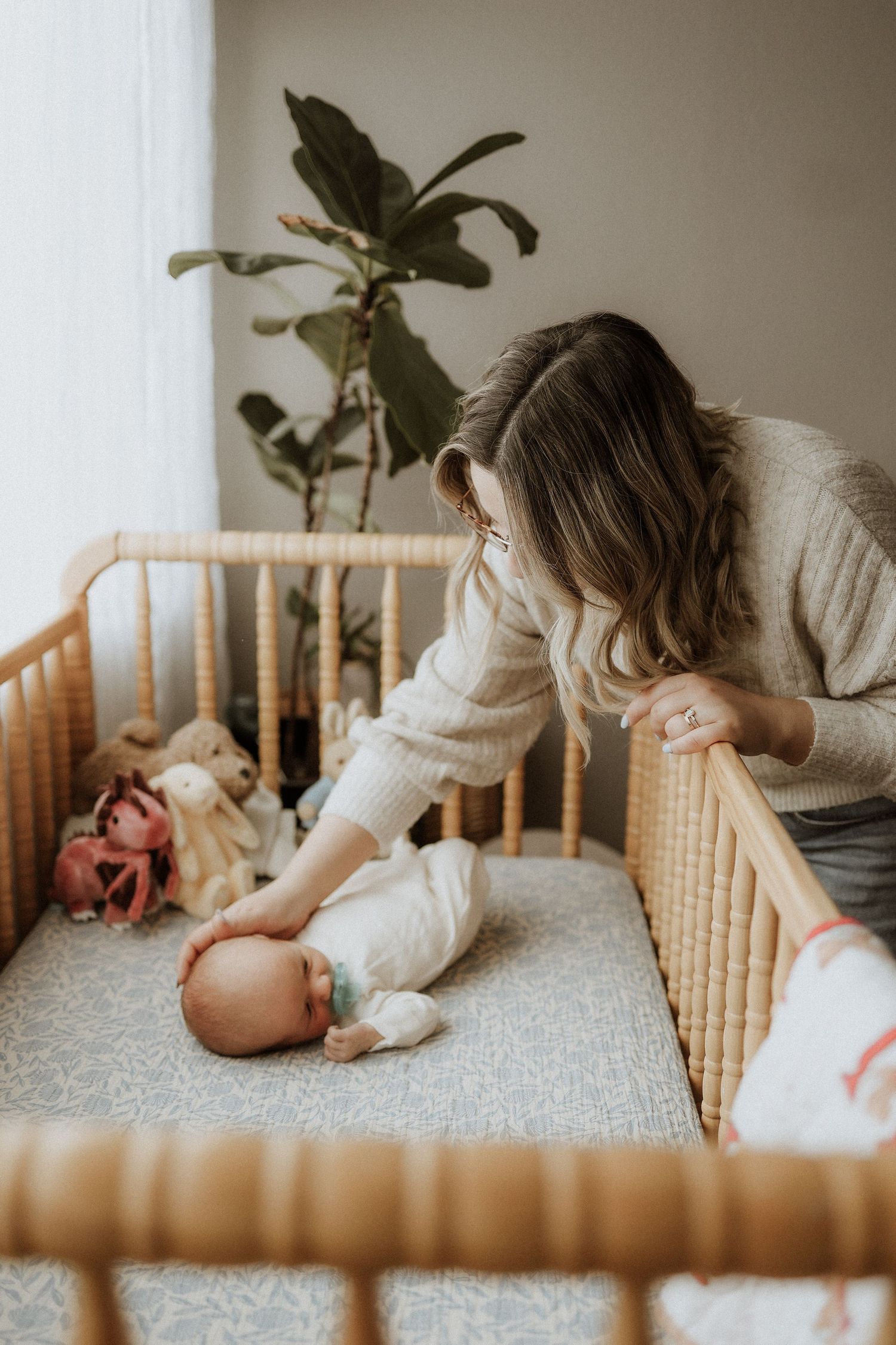 newborn baby and mom, crib, nursery, loving