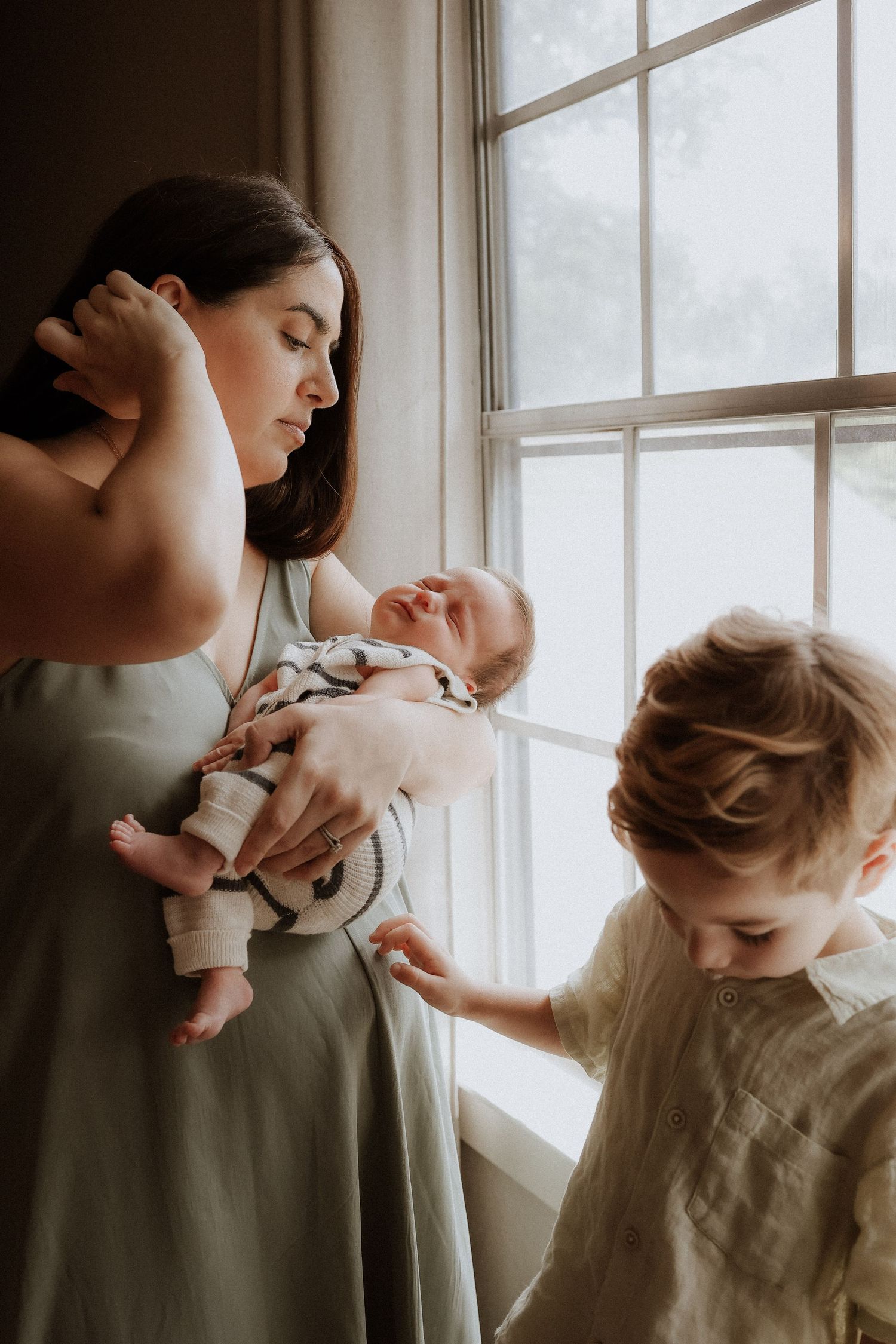 A tender moment between parent and child is captured in a series of soft, window-lit photographs.