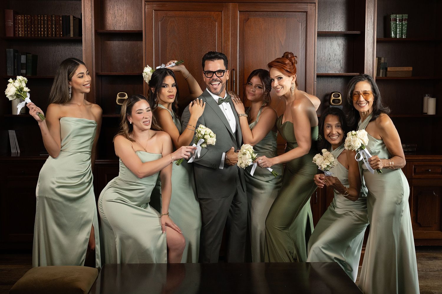 Groom with bridesmaids in sage green dresses at elegant venue — wedding photographer Puerto Rico Raymond Vega